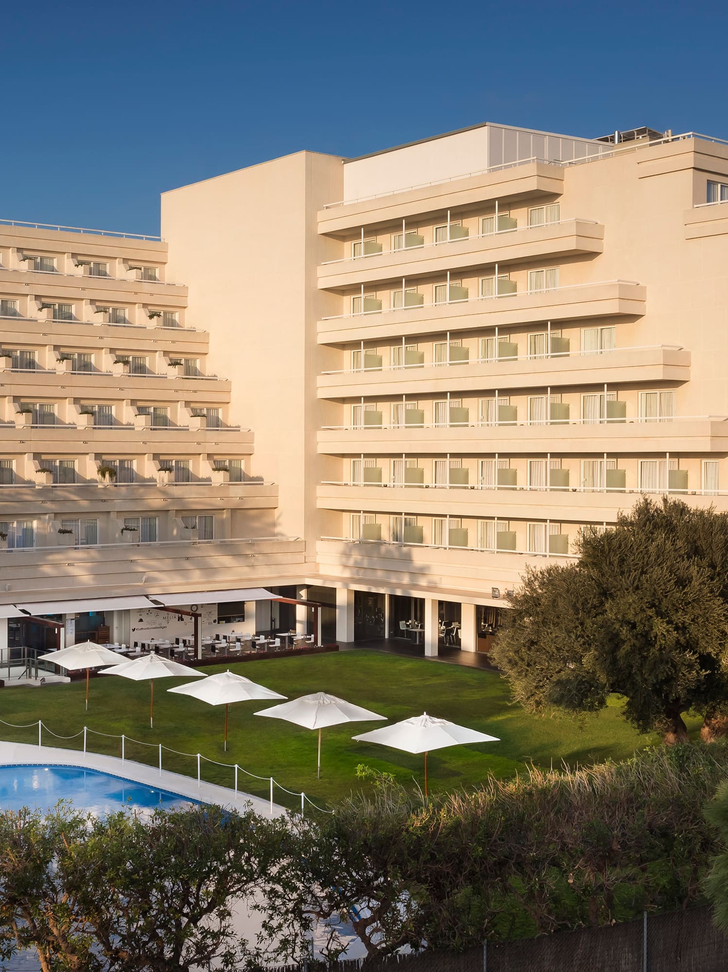 a large building with a pool and trees