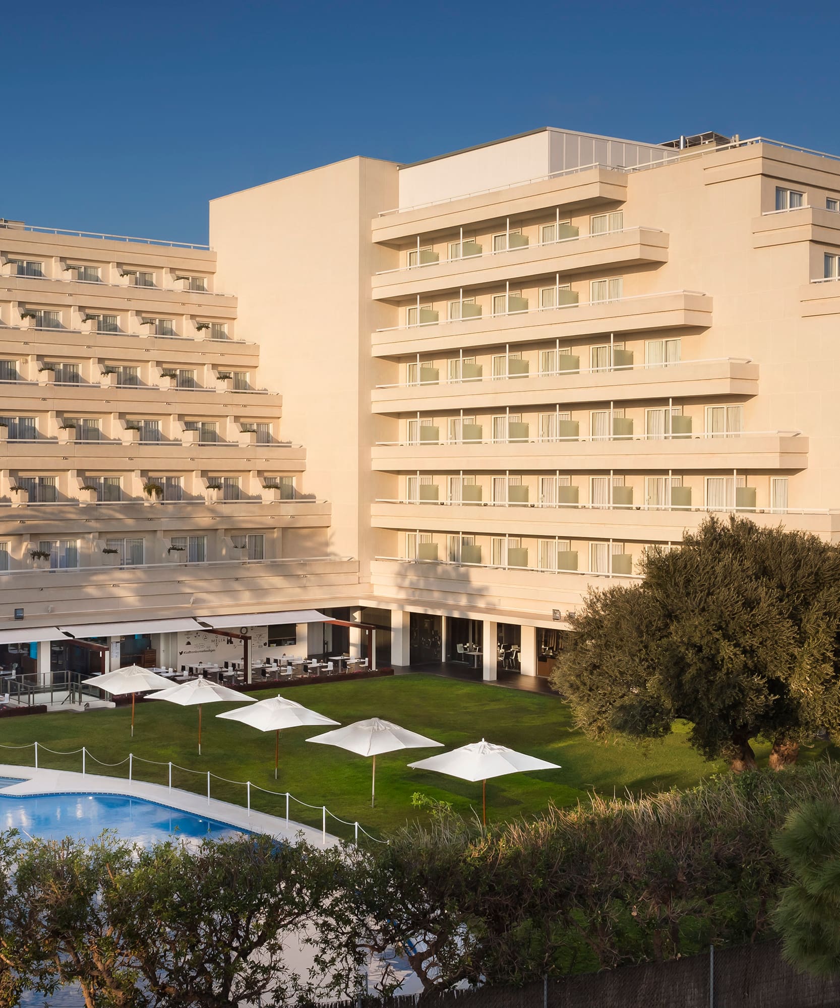 a large building with a pool and trees