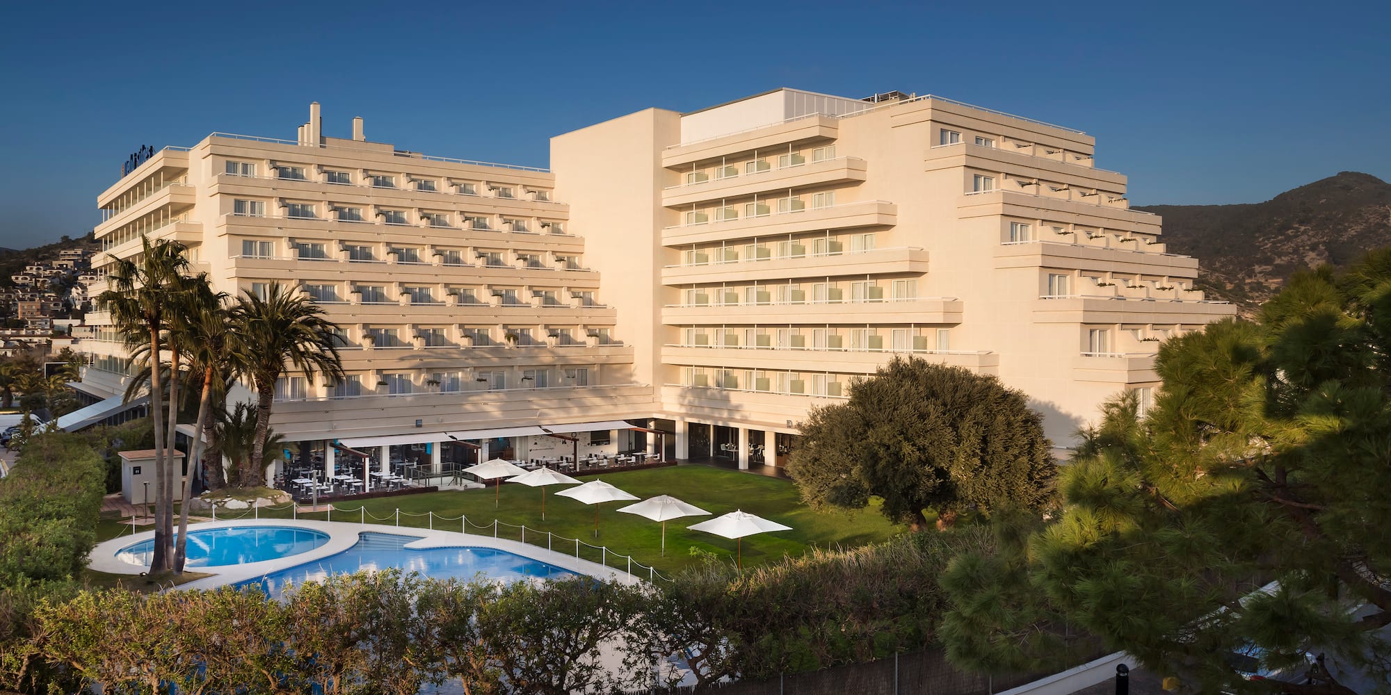 a large building with a pool and trees