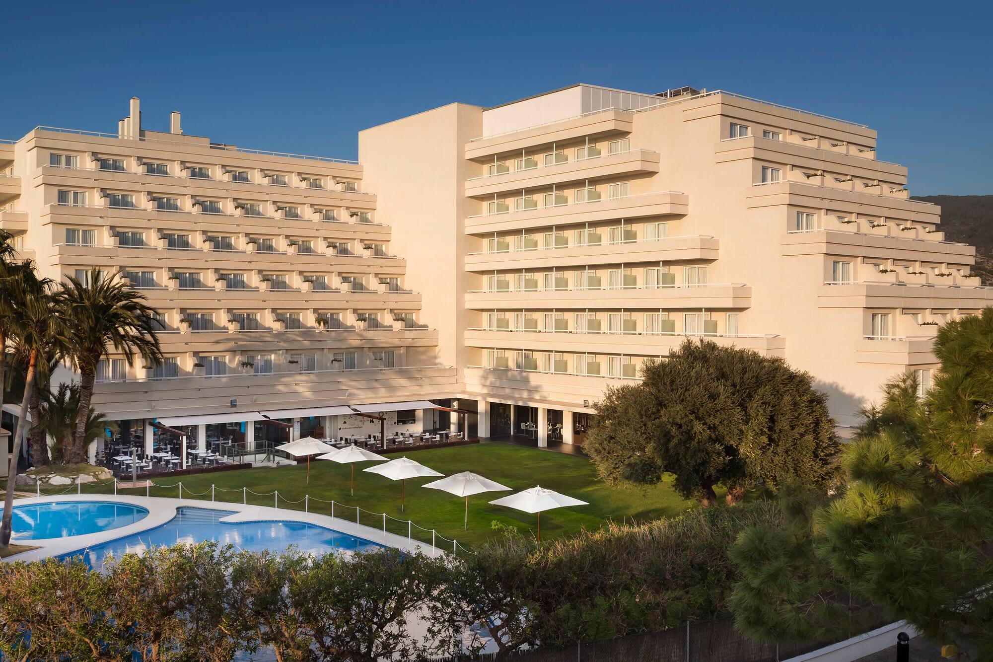 a large building with a pool and trees