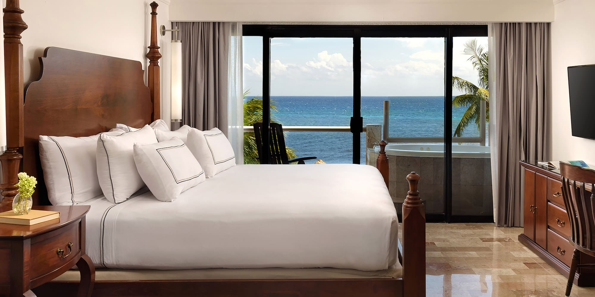 a bedroom with a large bed and a glass door