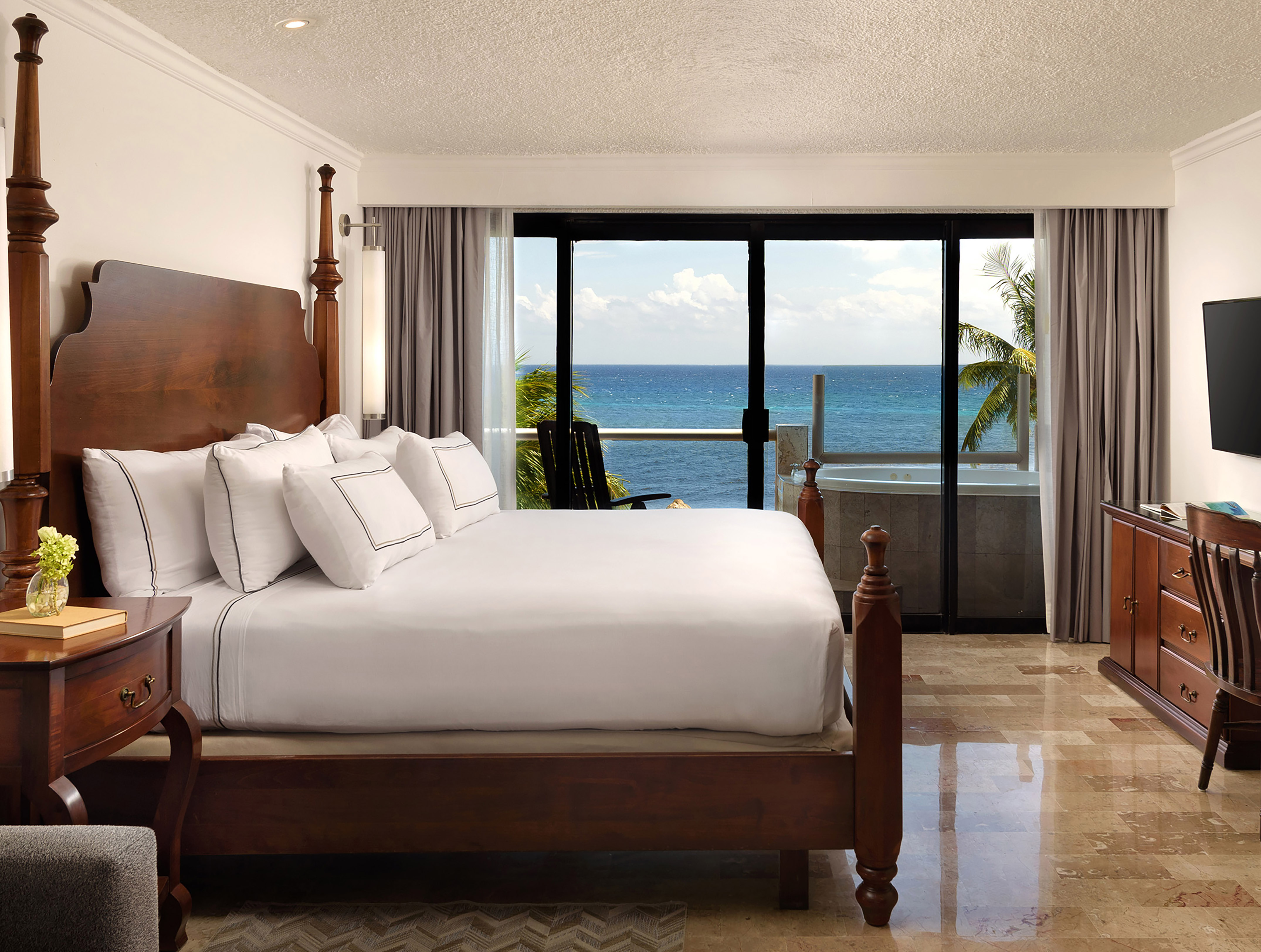 a bedroom with a large bed and a glass door