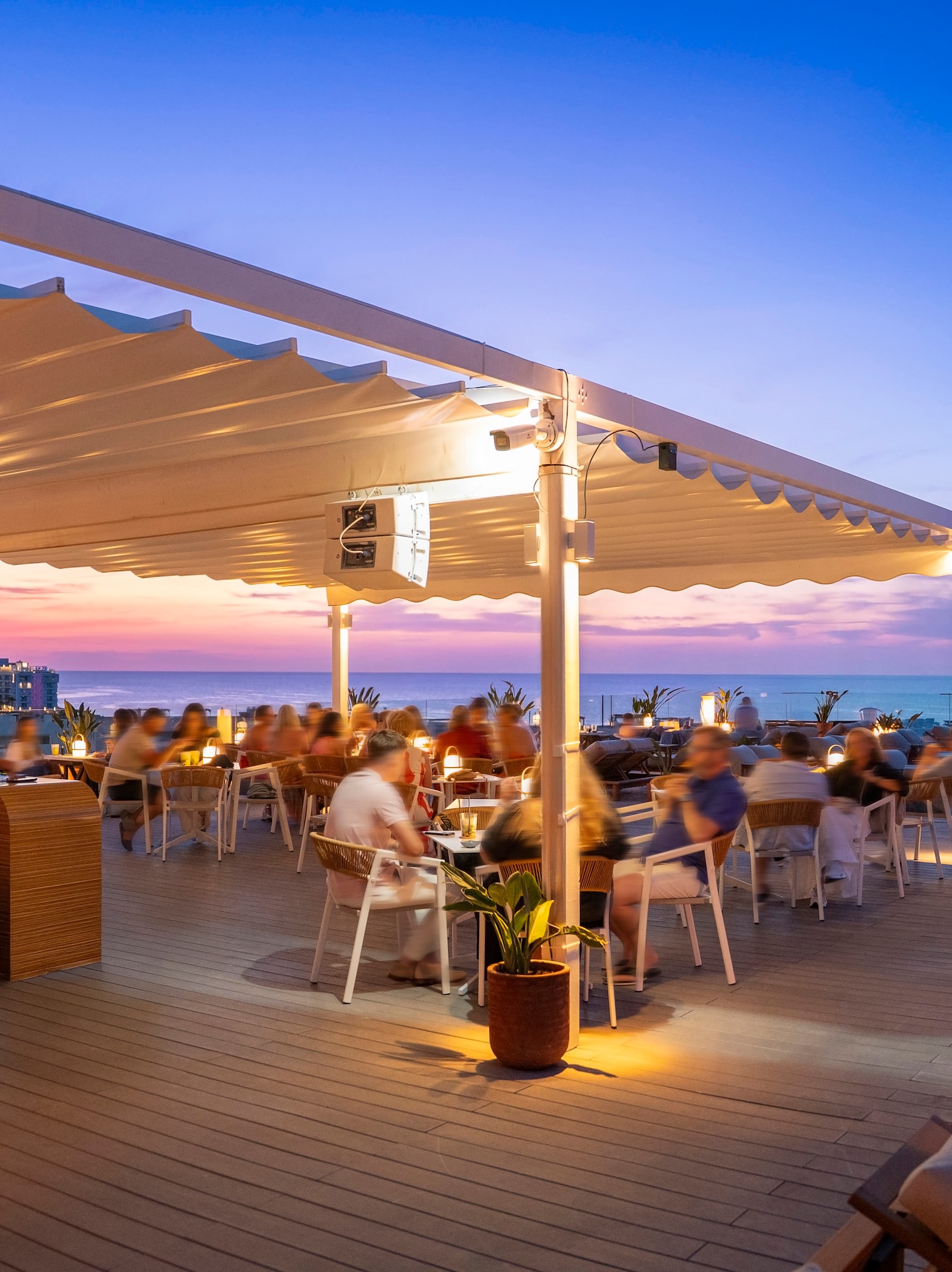 a group of people sitting at tables on a deck