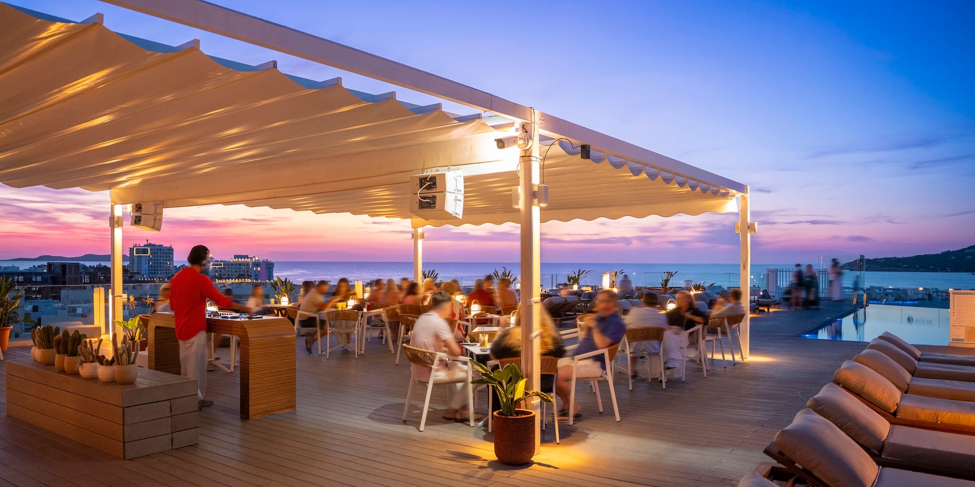 a group of people sitting at tables on a deck
