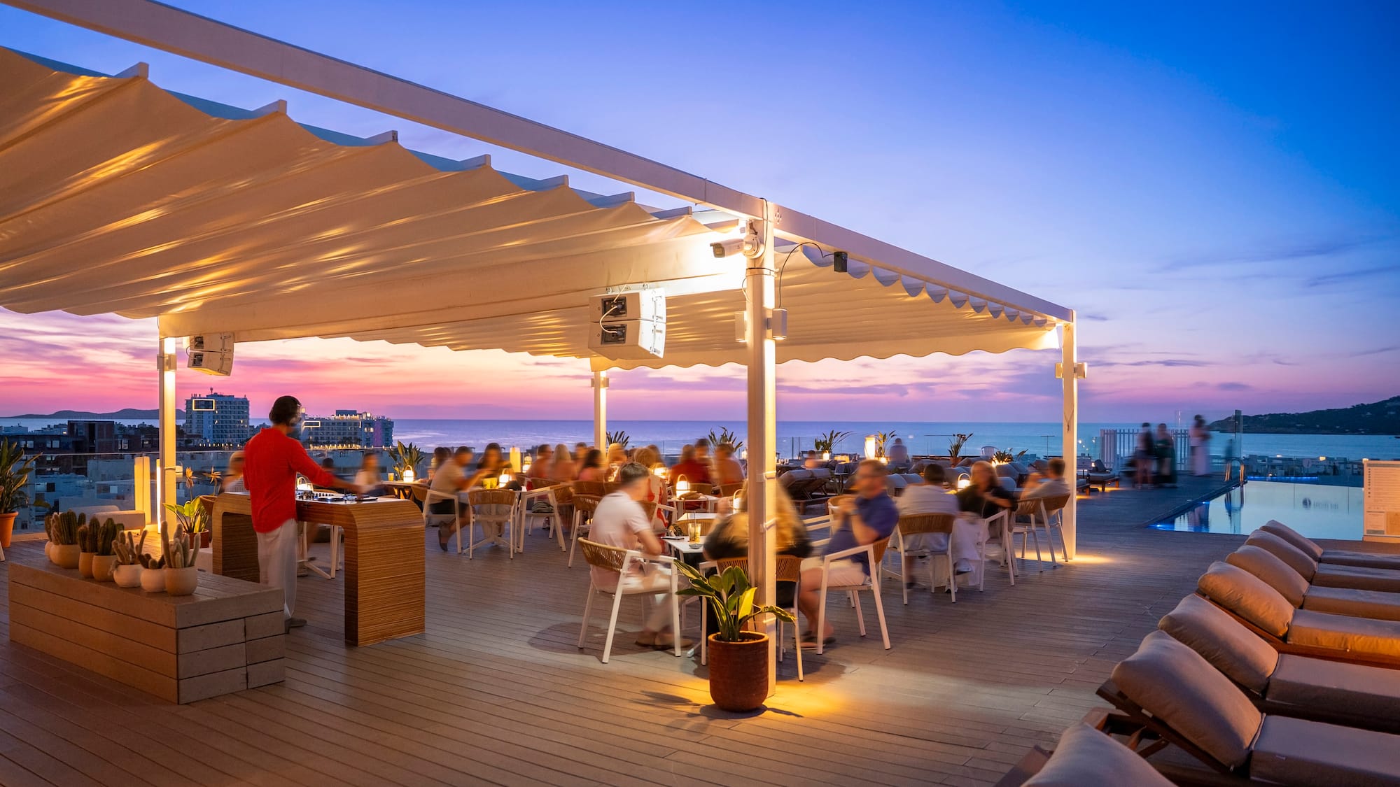 a group of people sitting at tables on a deck
