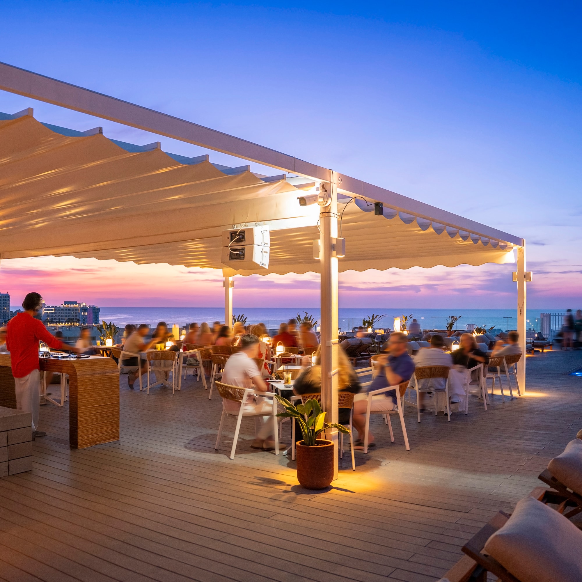 a group of people sitting at tables on a deck