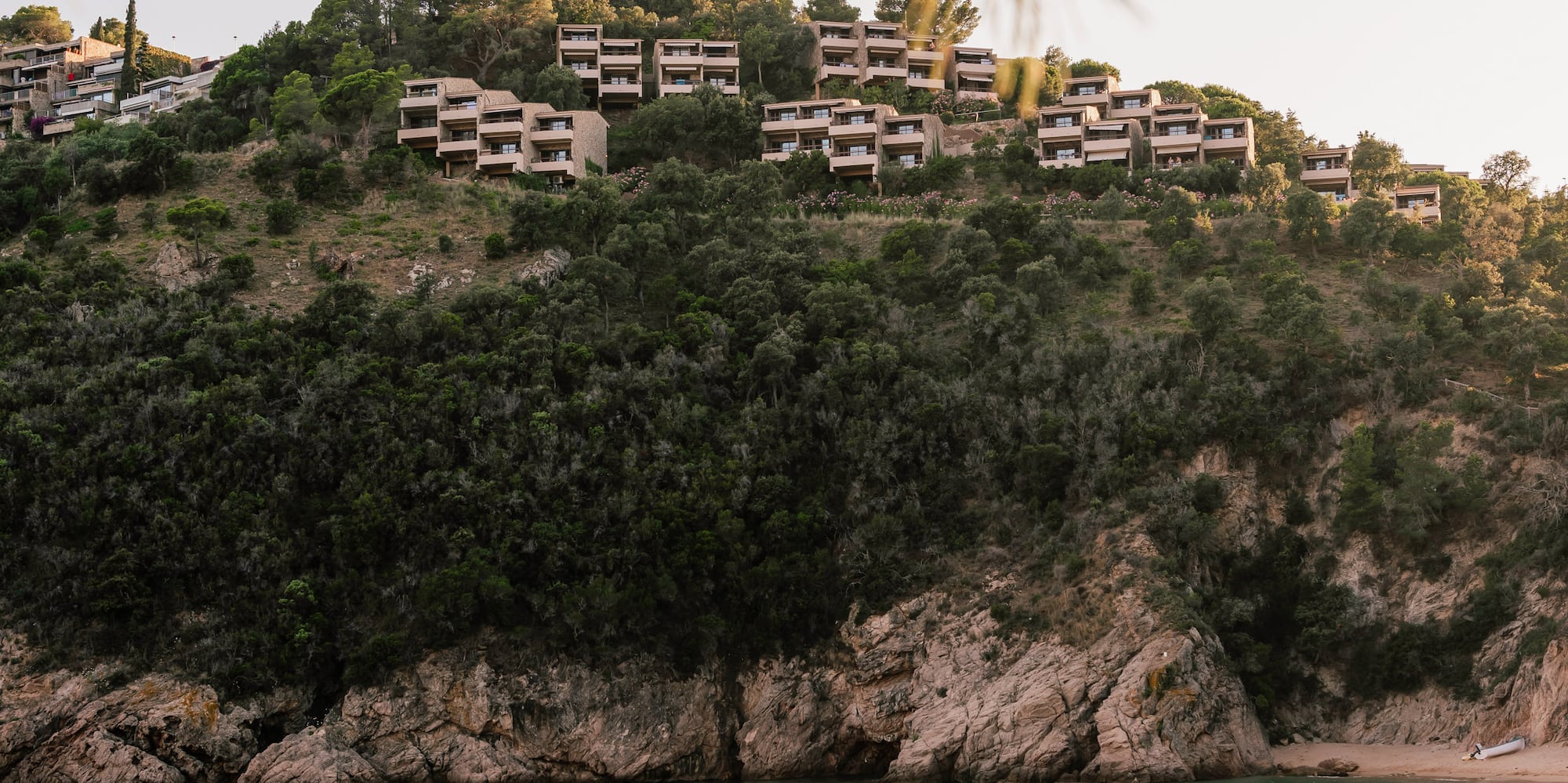 a group of people on a boat on a hill with buildings on top of it
