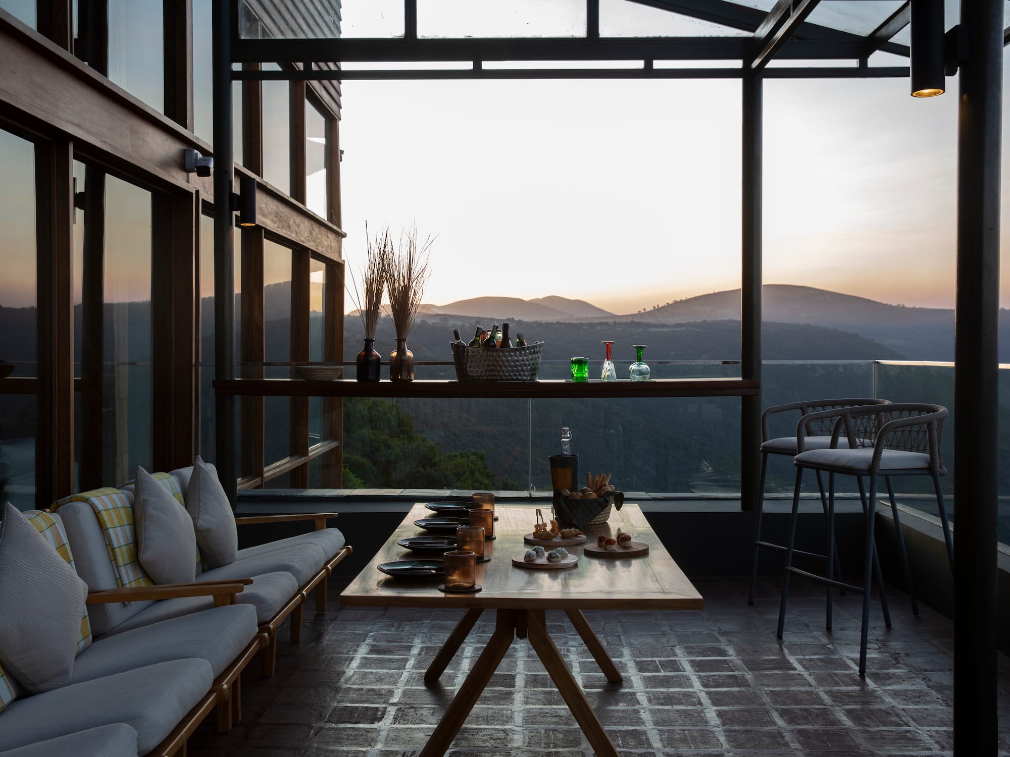a table with drinks on it and a couch with a view of the mountains