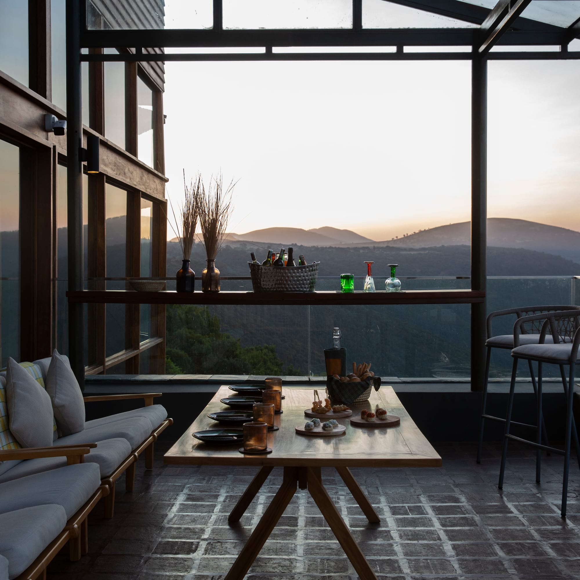 a table with drinks on it and a couch with a view of the mountains