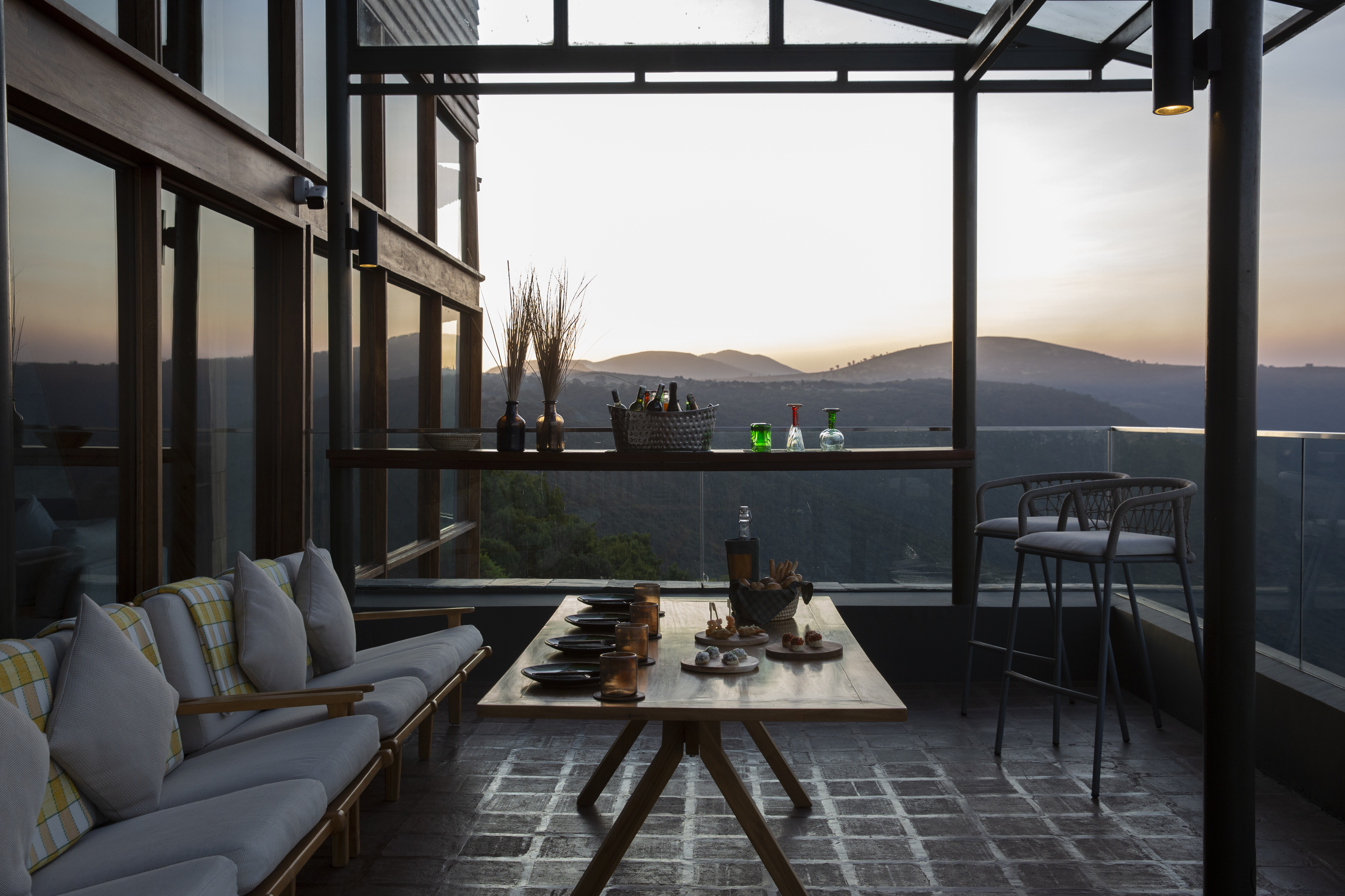 a table with drinks on it and a couch with a view of the mountains
