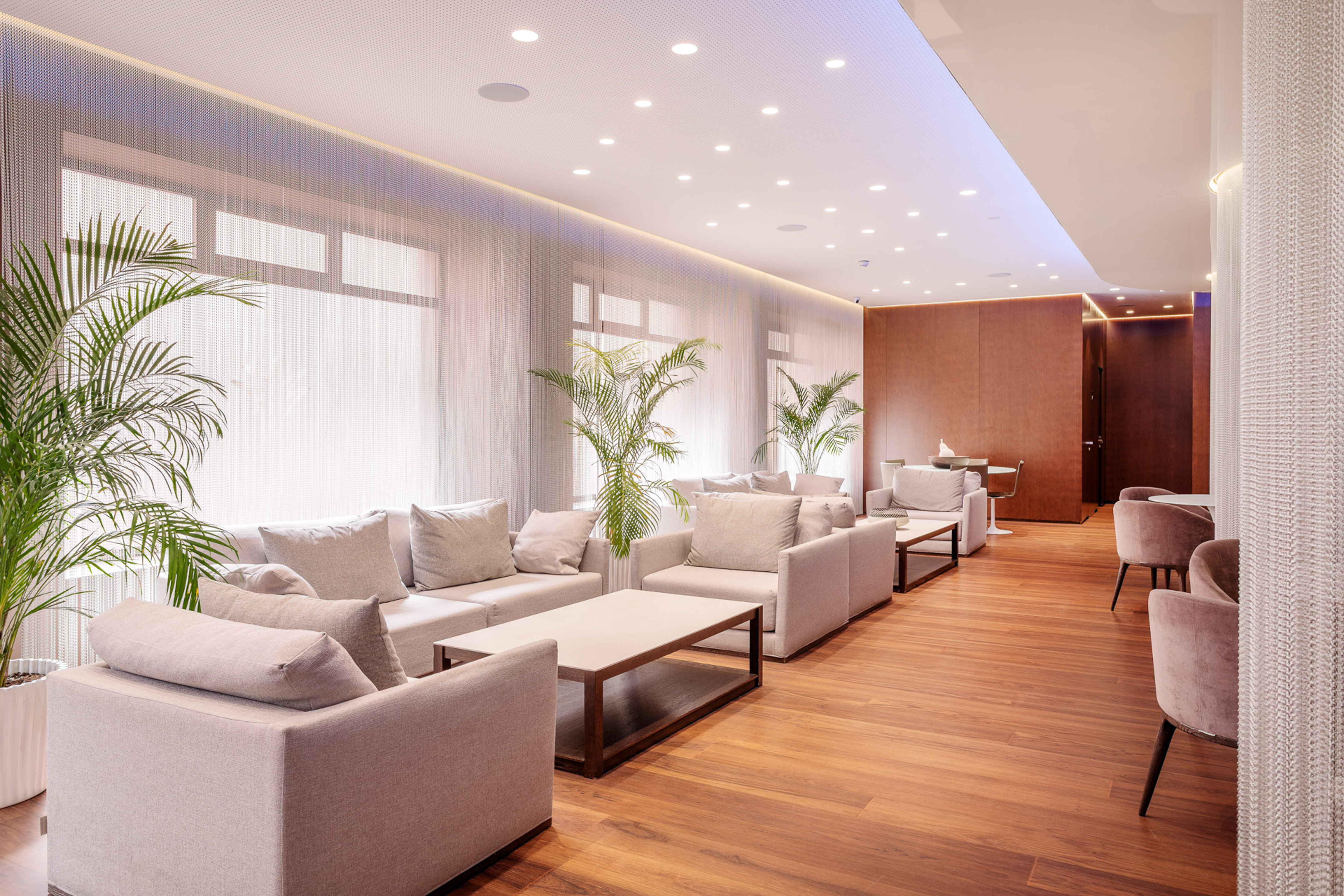 Hotel lounge area with modern light sofas, wood floor, and potted plants. - Hotel Murcia Rincón de Pepe Affiliated by Meliá, Murcia