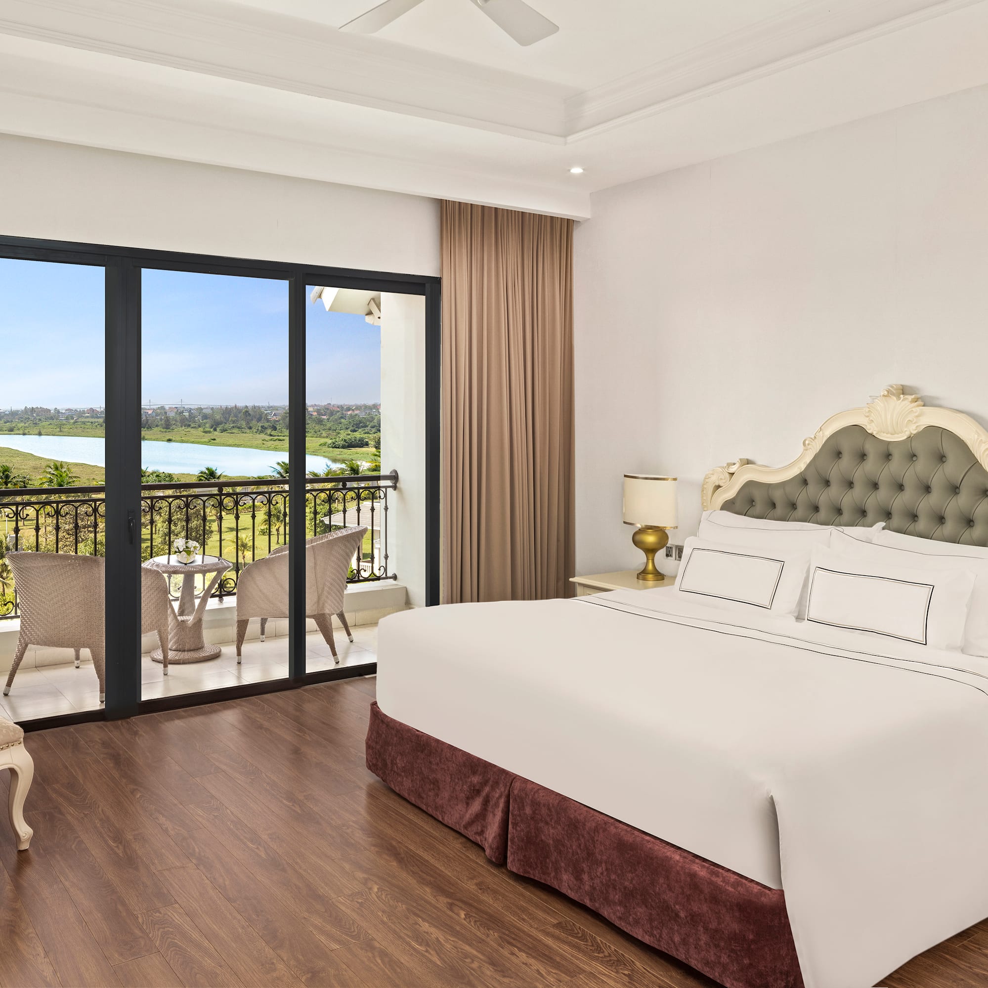 a bedroom with a balcony and a view of the river