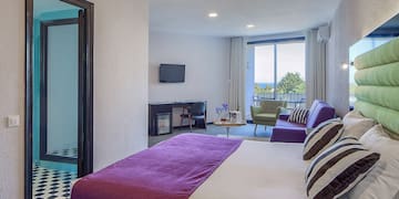 a bedroom with a purple bed and purple couches
