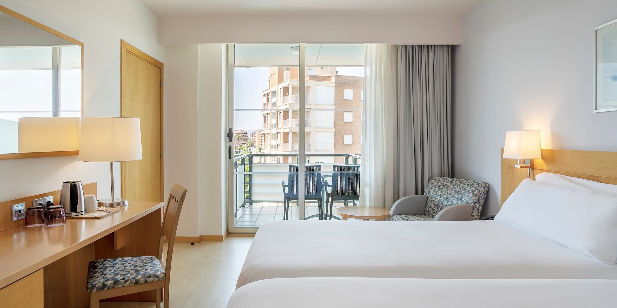 a room with two beds and a desk and chair