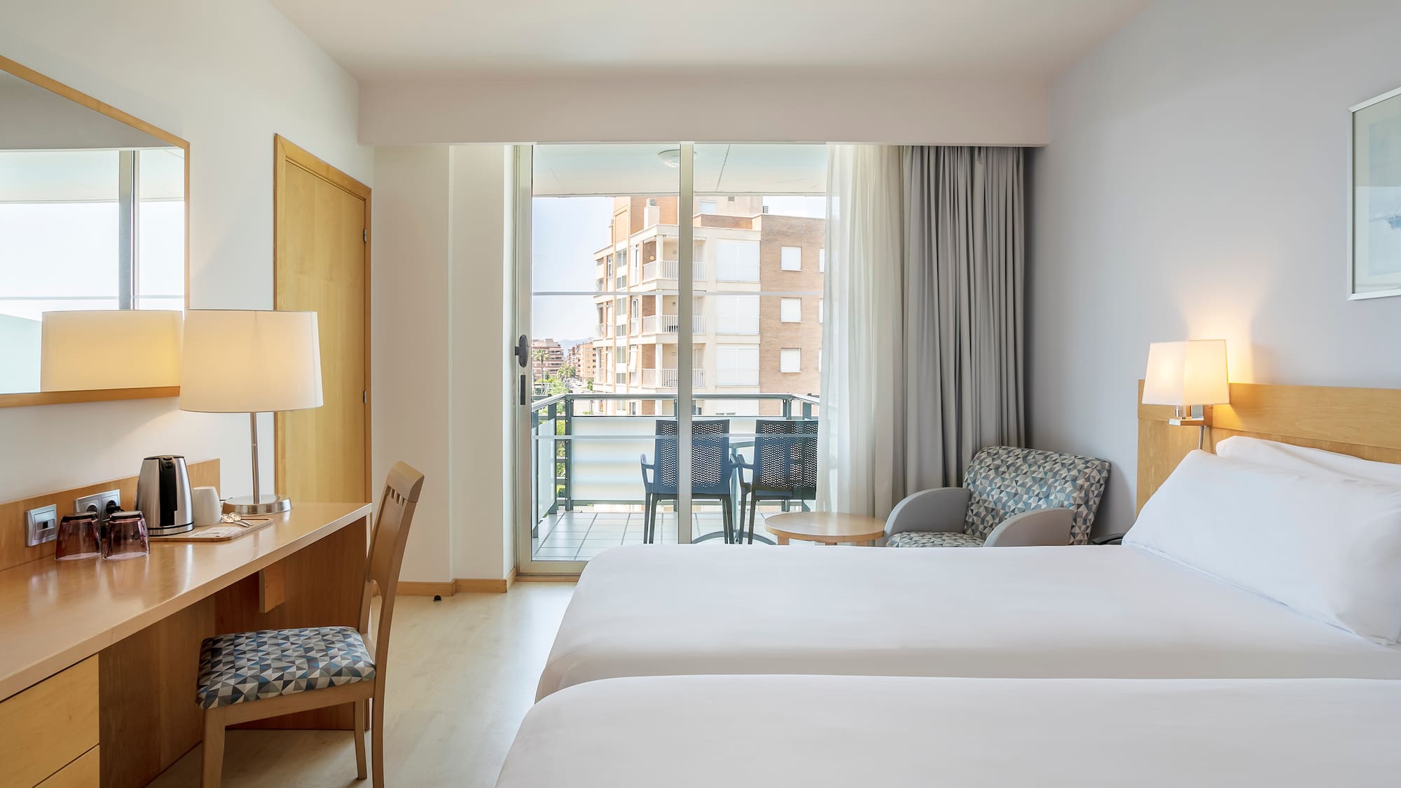 a room with two beds and a desk and chair