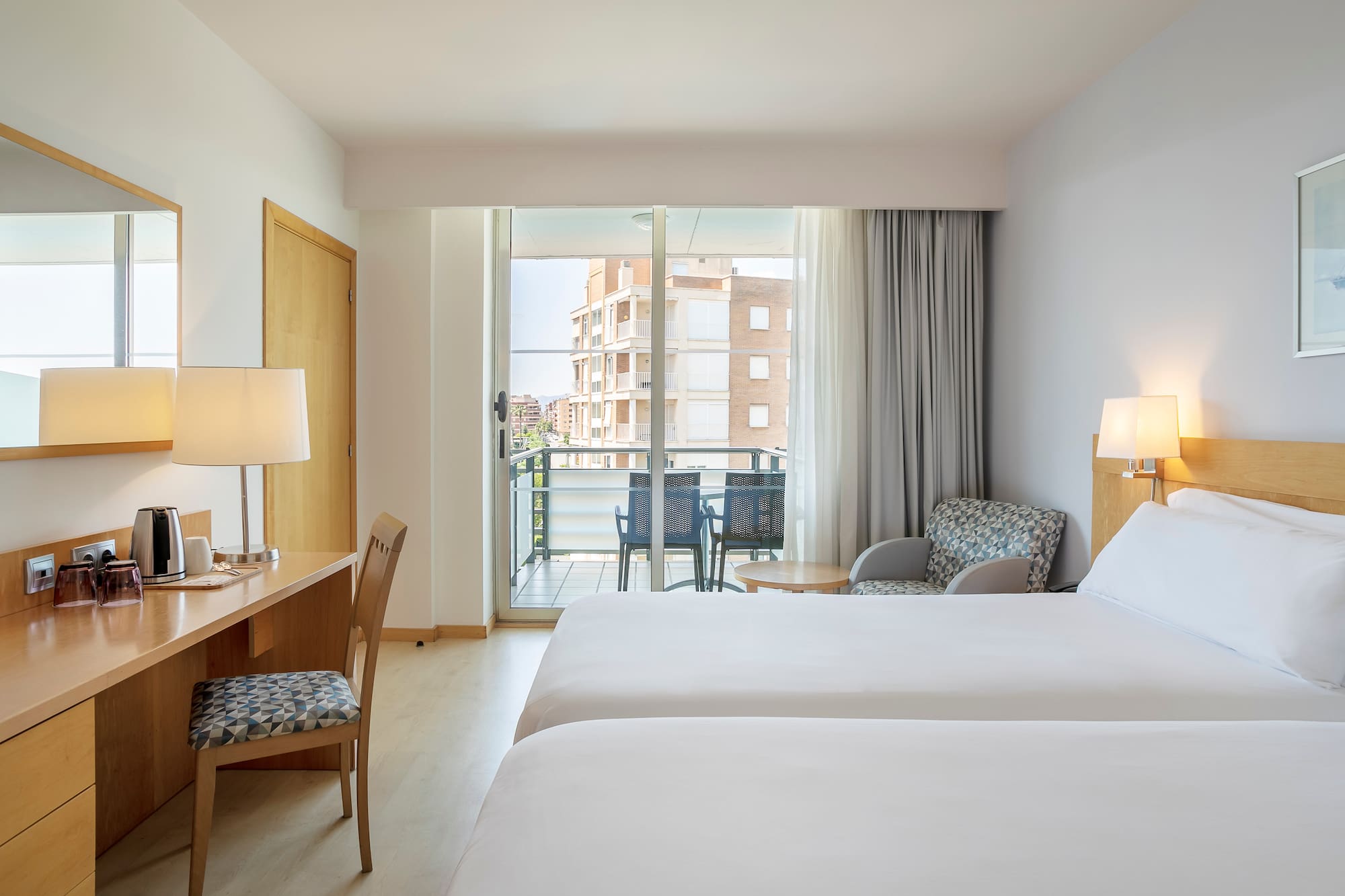 a room with two beds and a desk and chair