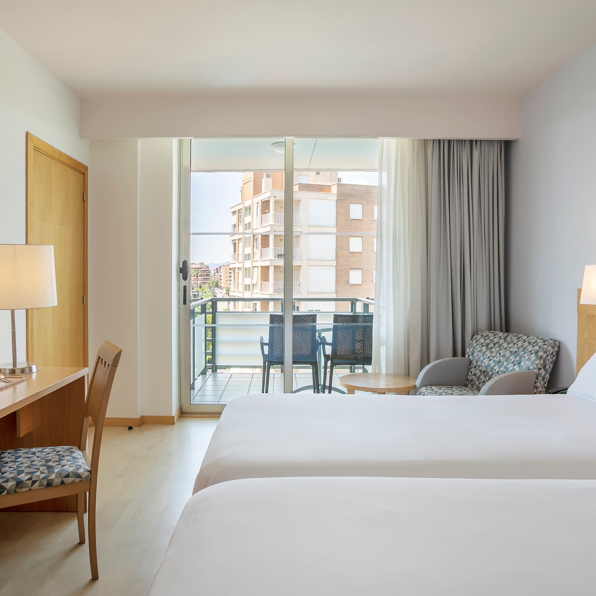 a room with two beds and a desk and chair