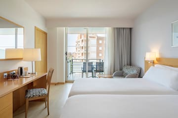 a room with two beds and a desk and chair