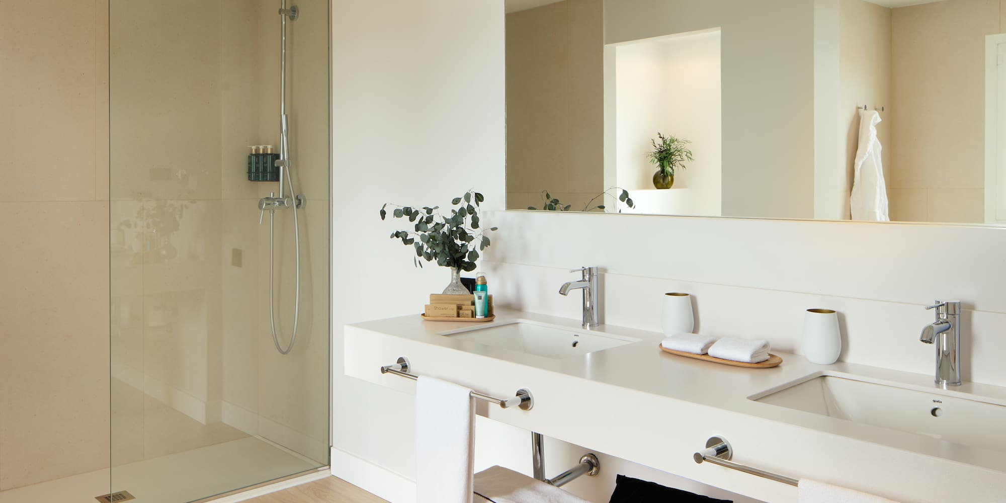 a bathroom with a glass shower and a sink.