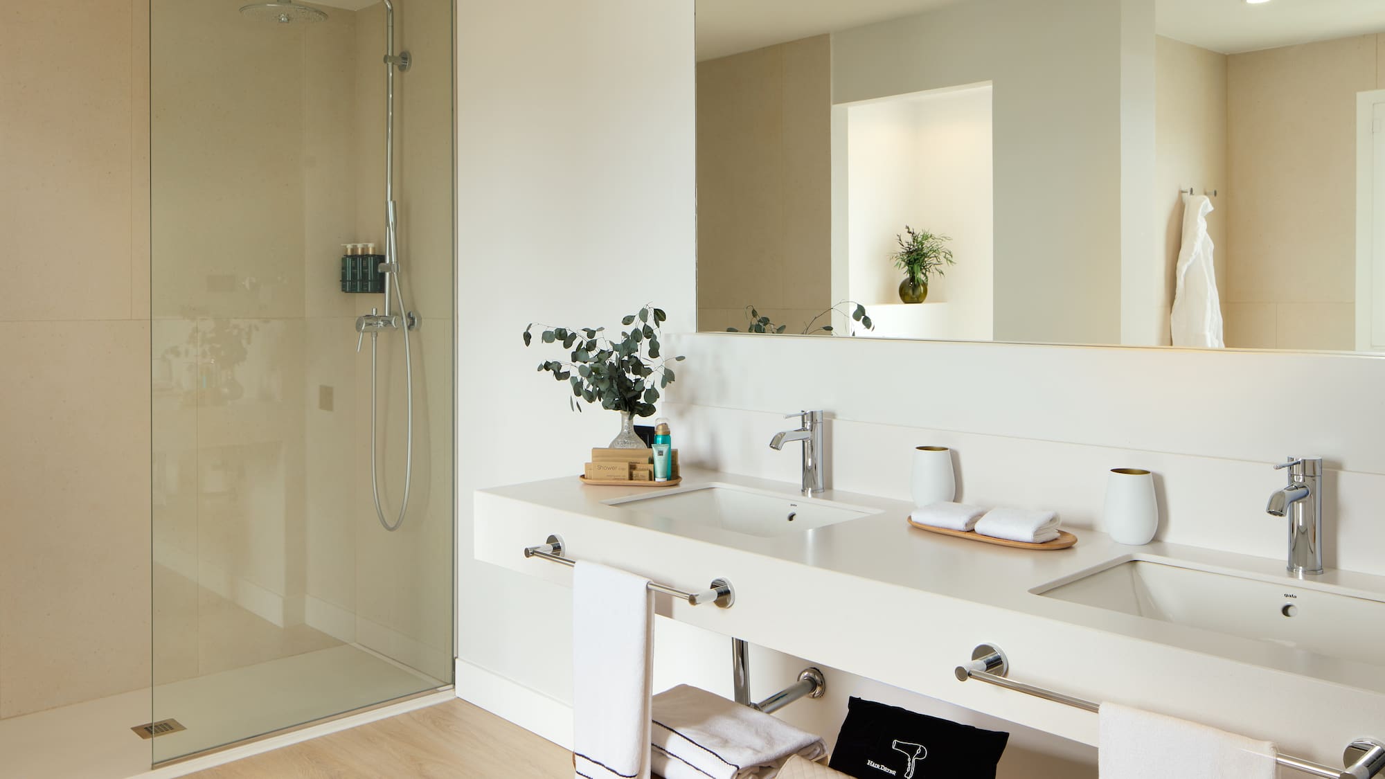 a bathroom with a glass shower and a sink.