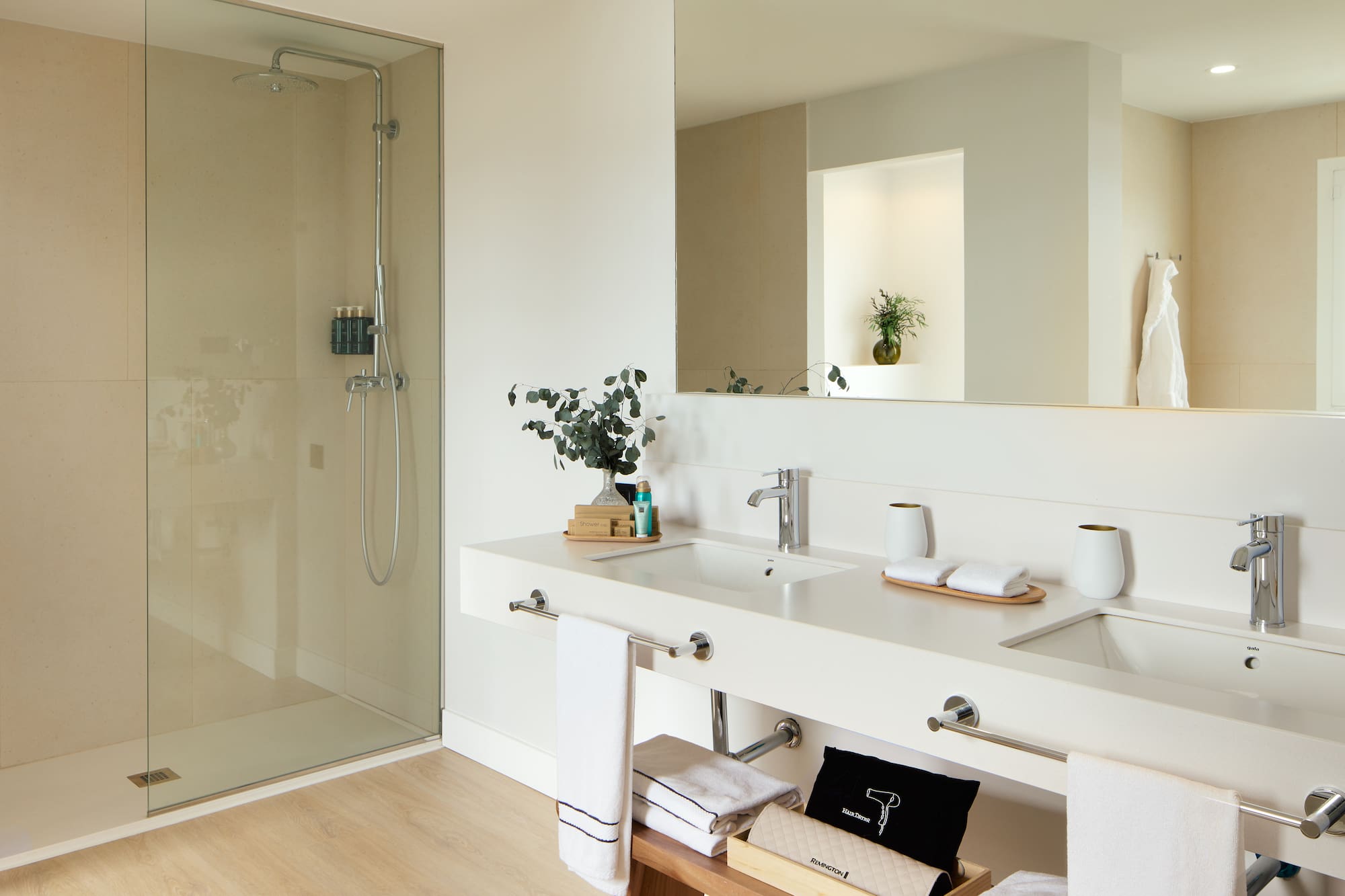 a bathroom with a glass shower and a sink.
