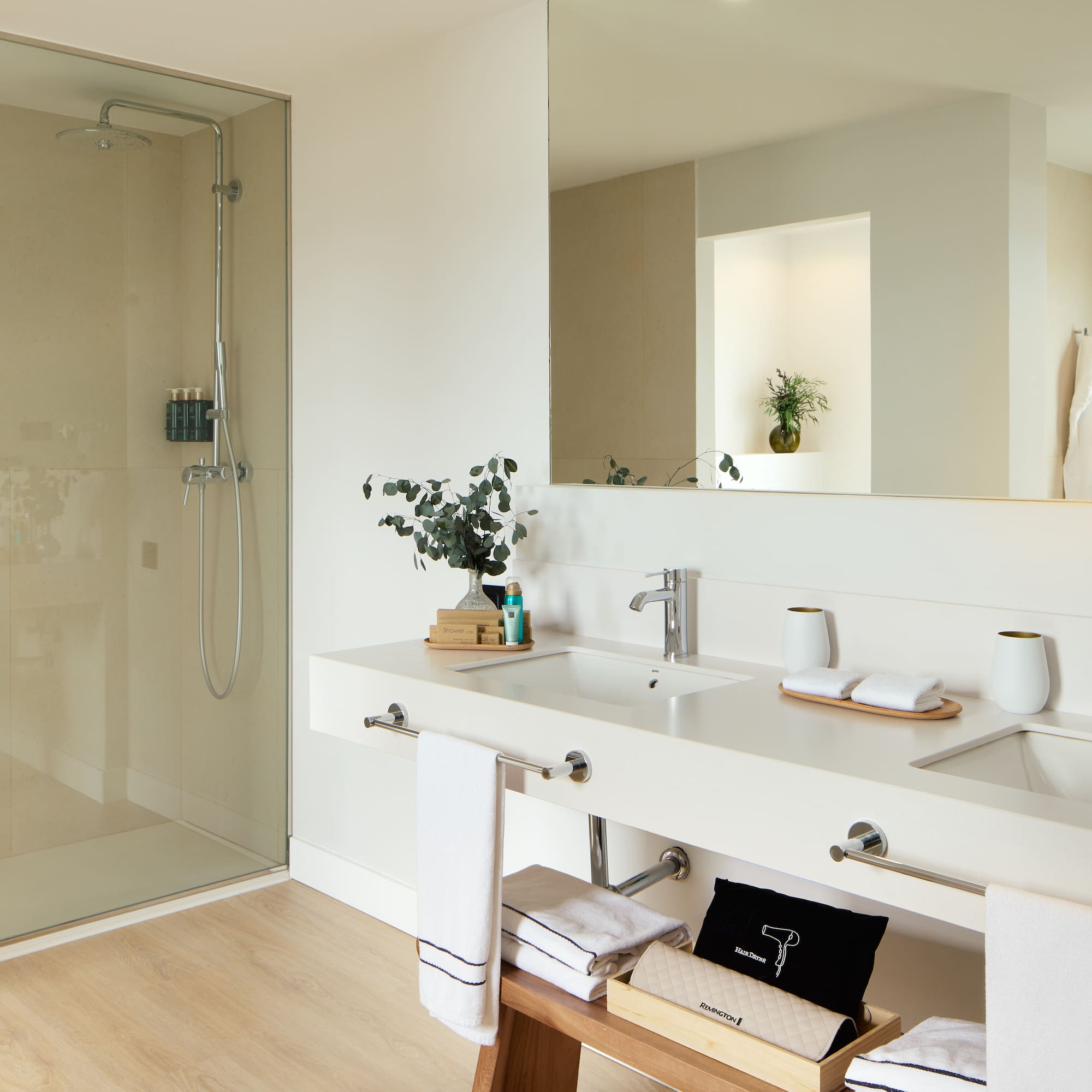 a bathroom with a glass shower and a sink.
