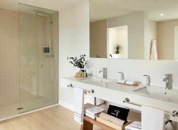 a bathroom with a glass shower and a sink.