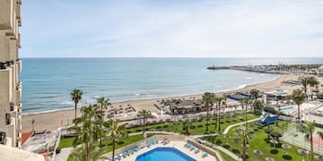 a pool and beach with palm trees and a pier