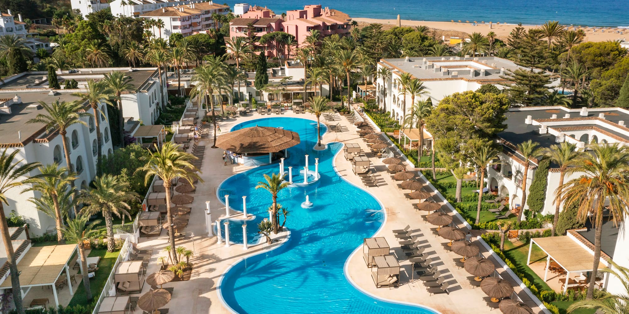 a swimming pool with a beach and buildings