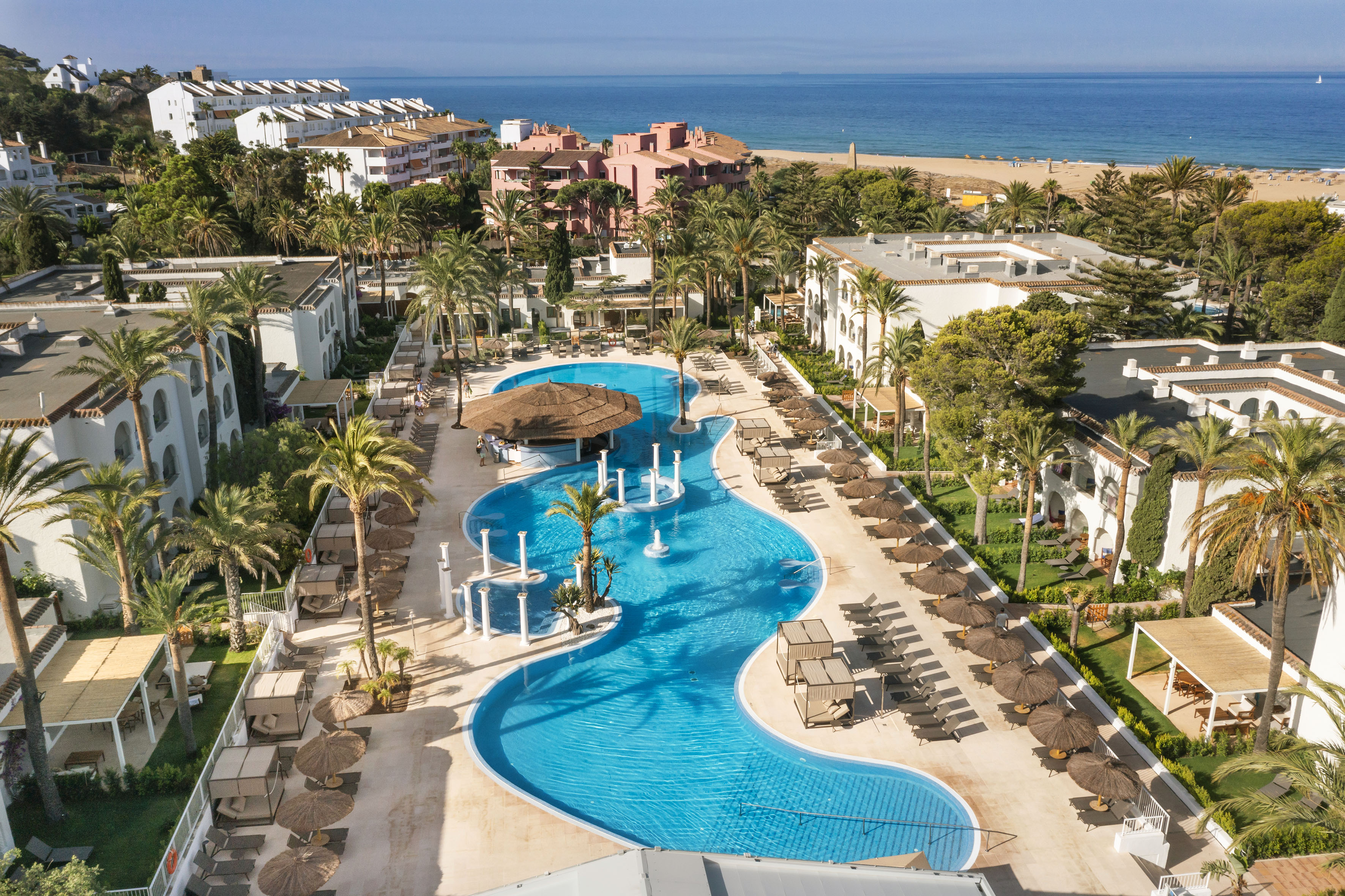 a swimming pool with a beach and buildings
