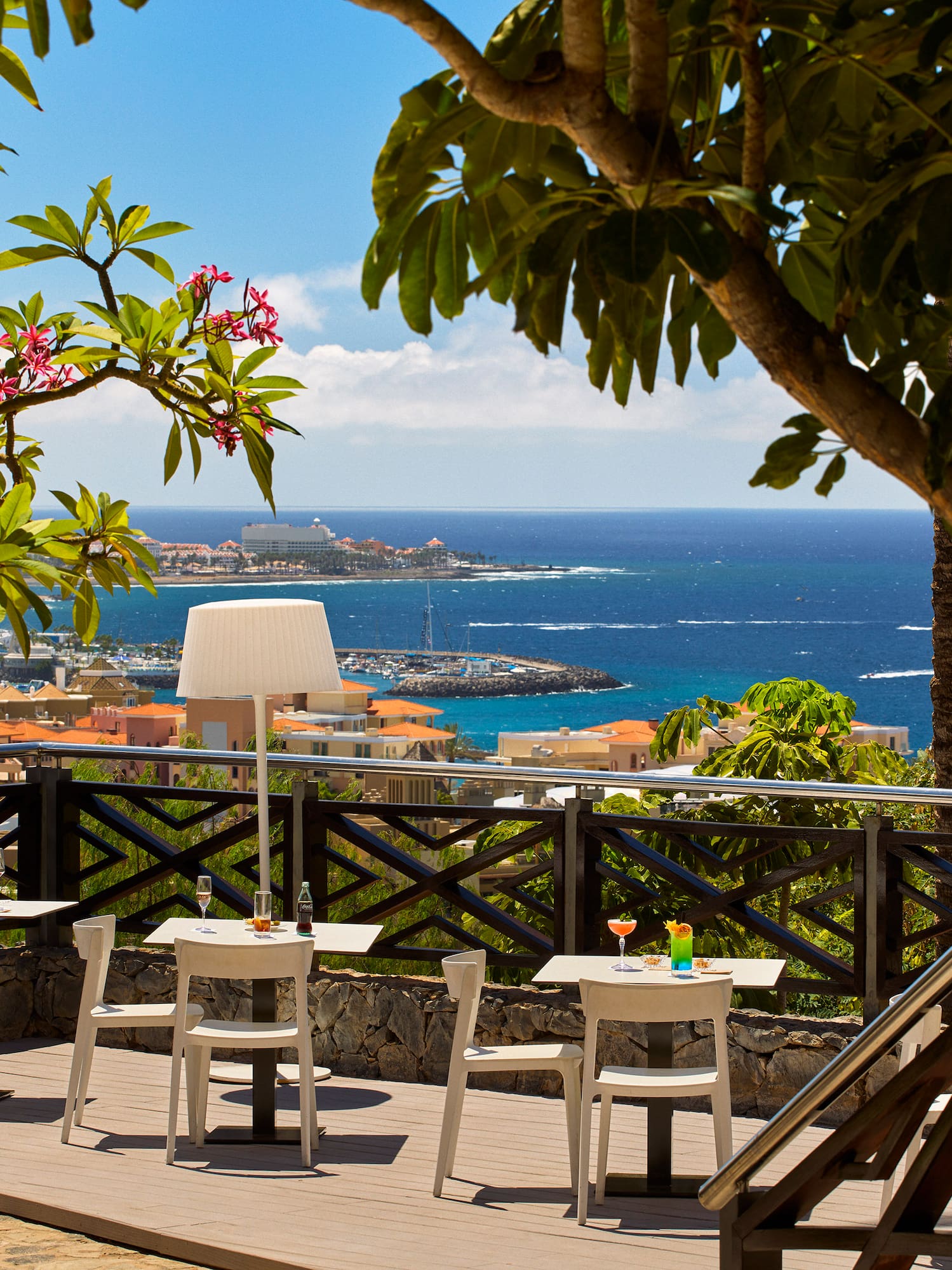 a table and chairs on a deck overlooking a body of water