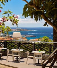 a table and chairs on a deck overlooking a body of water
