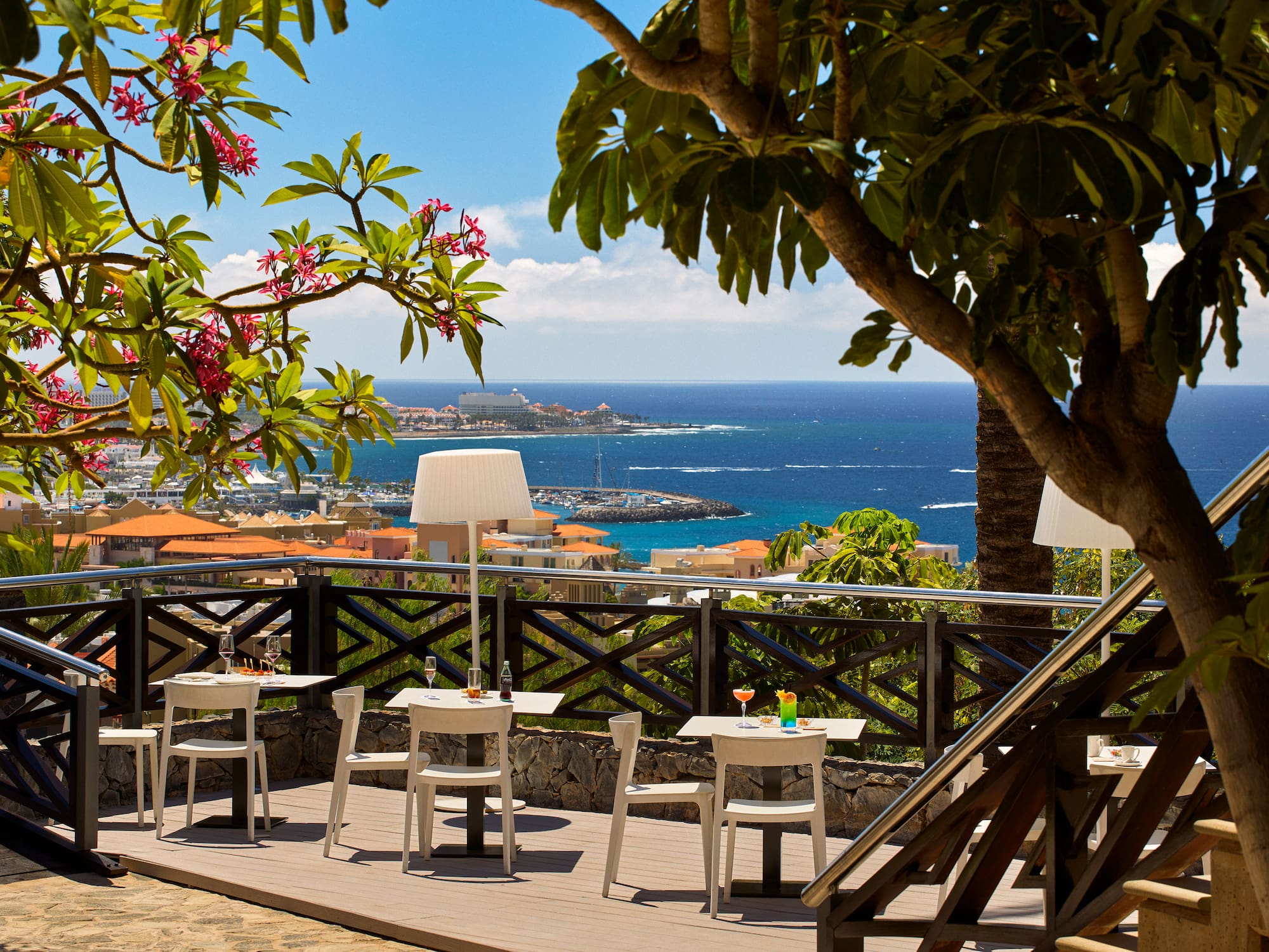 a table and chairs on a deck overlooking a body of water