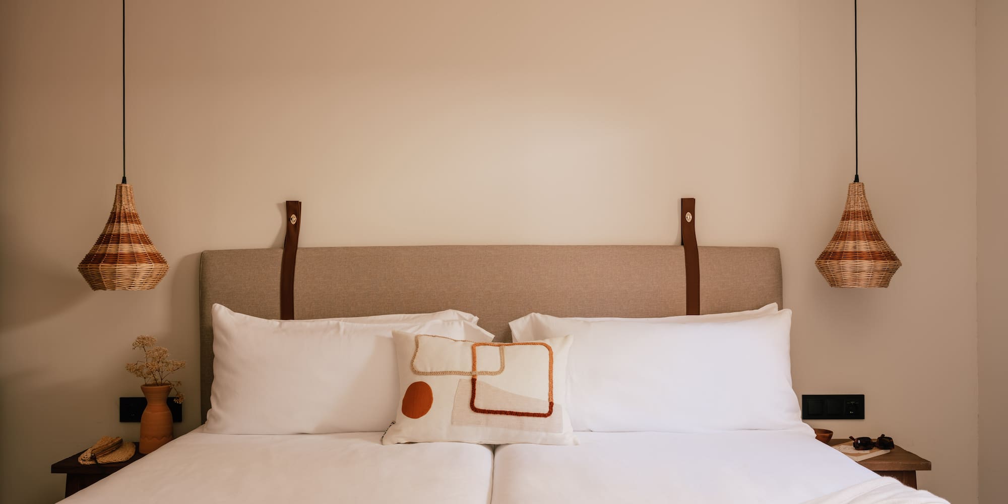 a bed with pillows and lamps