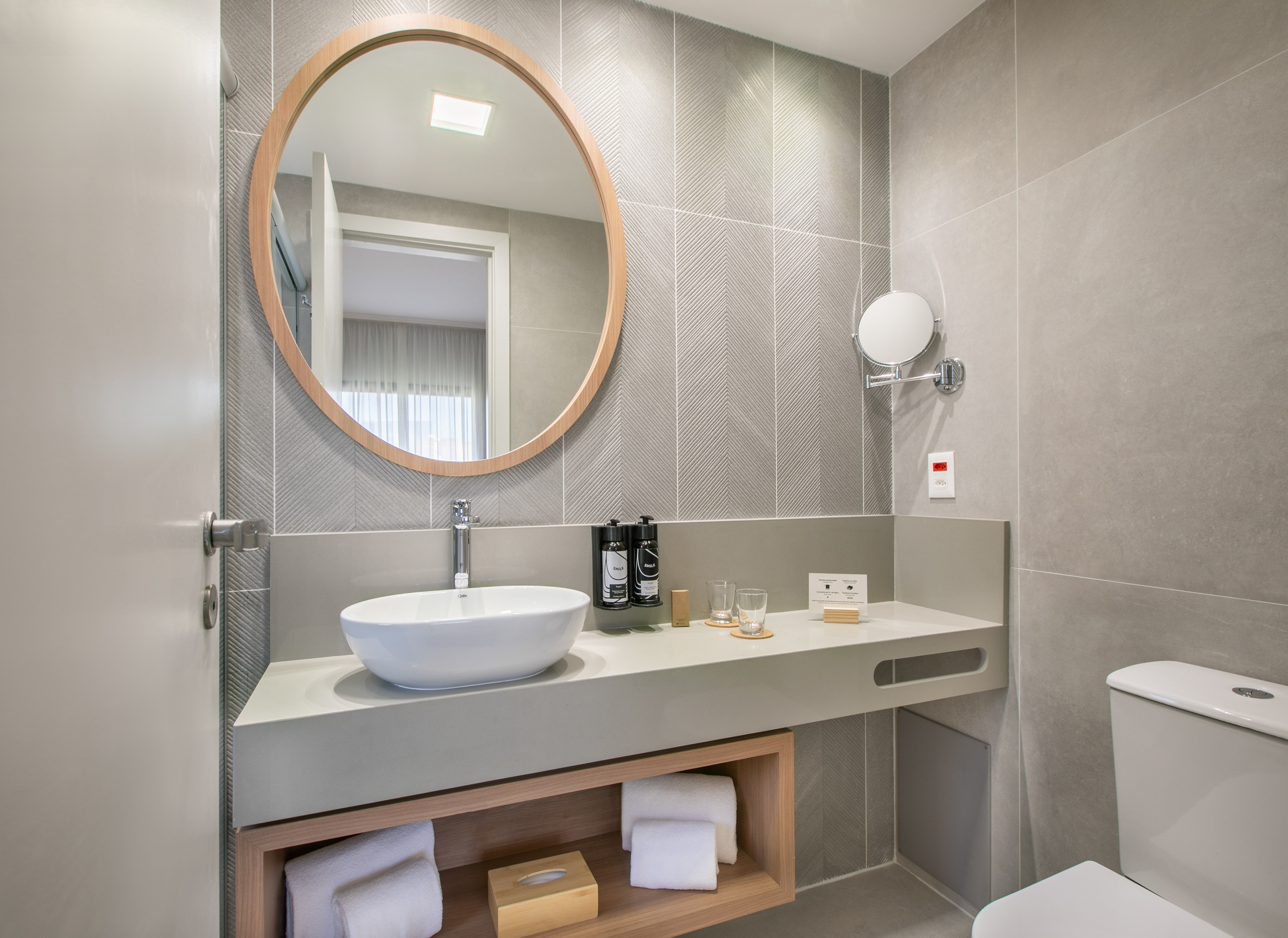 a bathroom with a round mirror