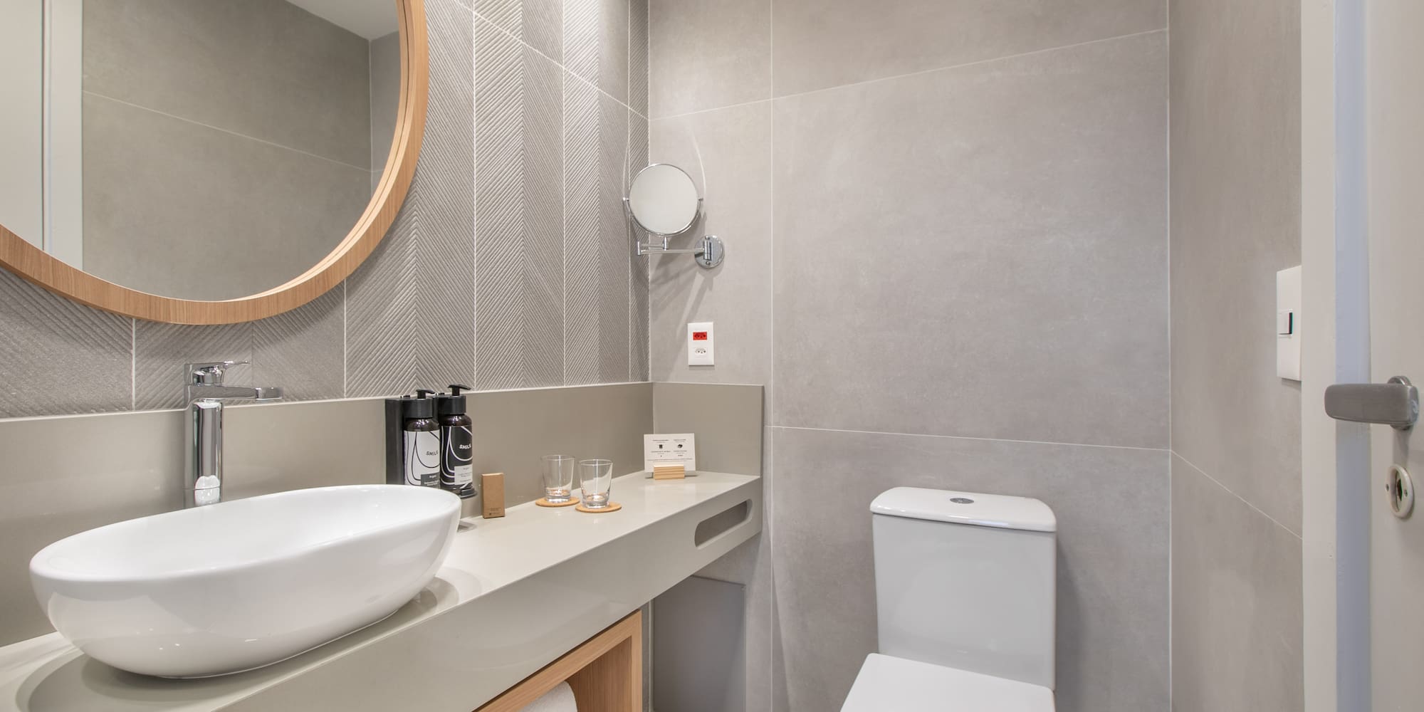 a bathroom with a round mirror and sink