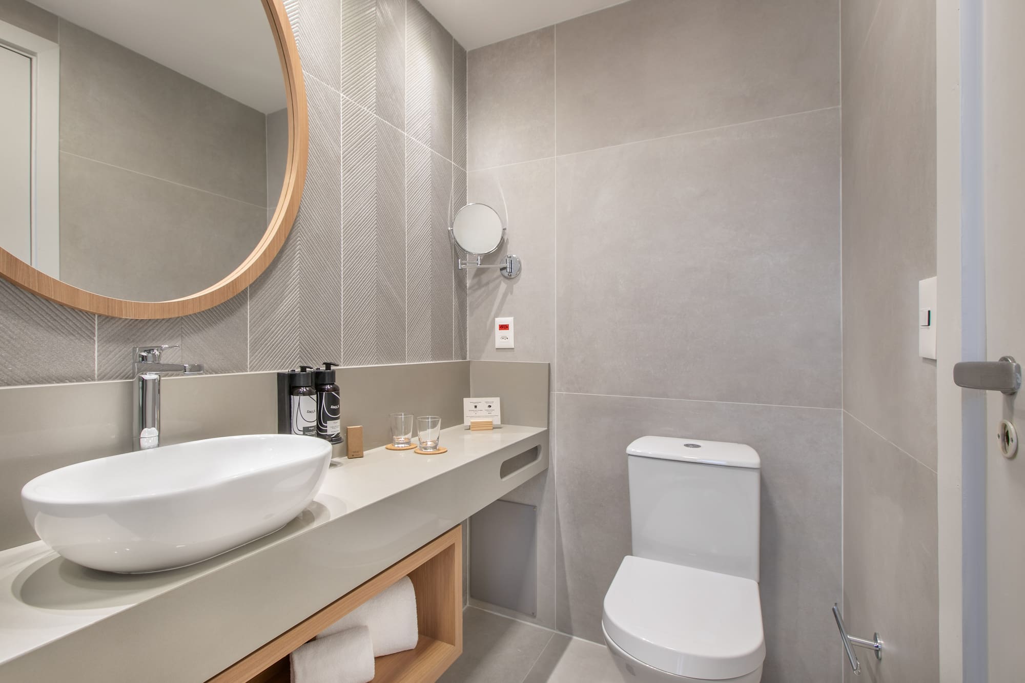 a bathroom with a round mirror and sink