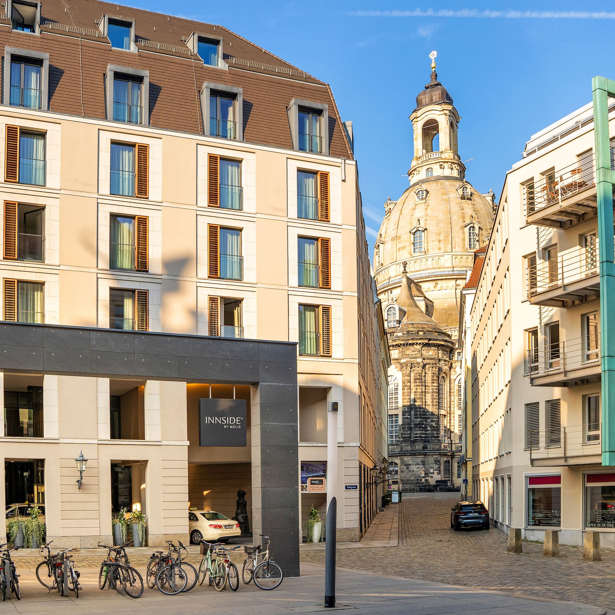 INNSIDE by Meliá Dresden hotel with Frauenkirche dome and bicycles outside.