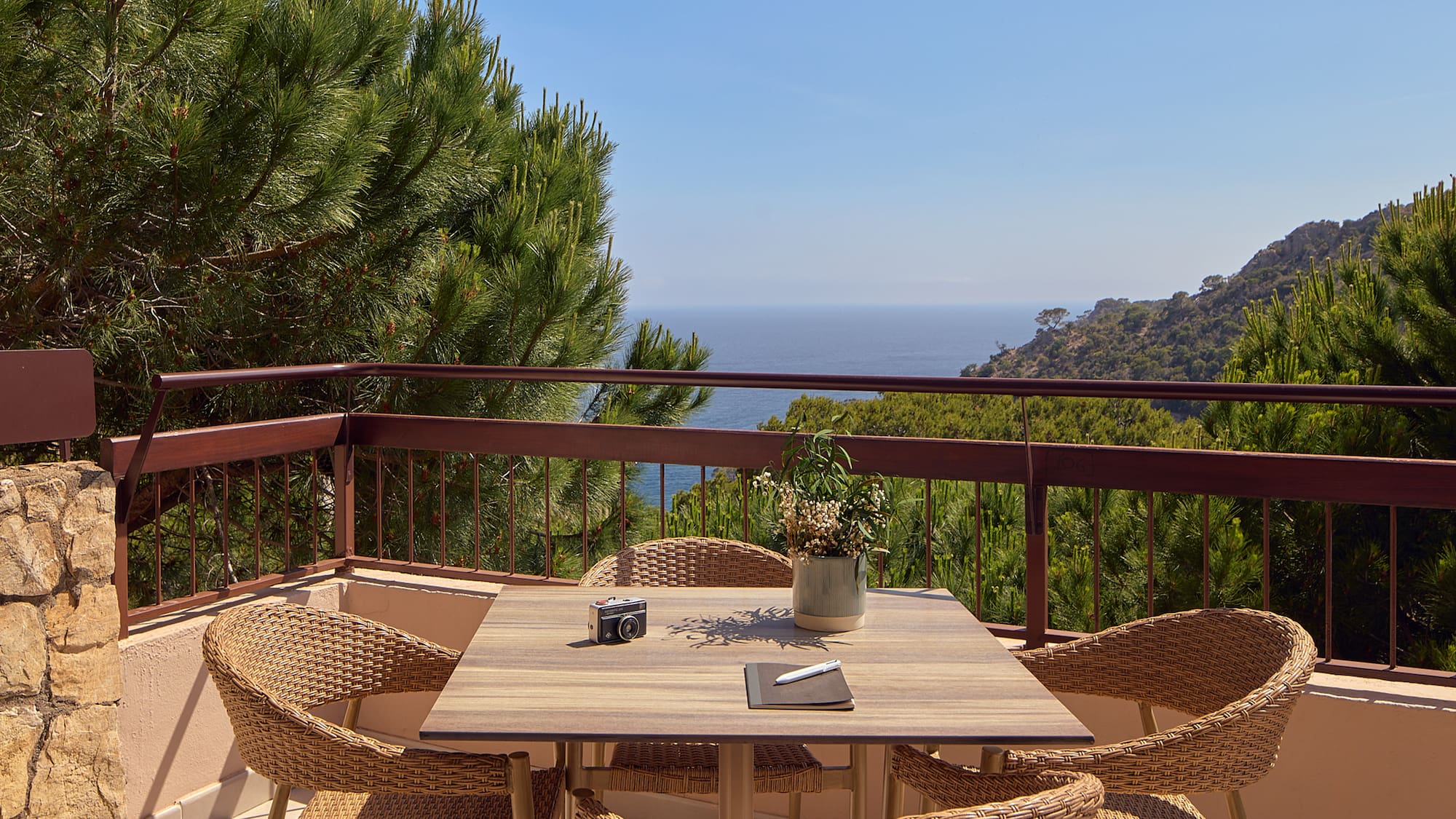 a table and chairs on a balcony overlooking a body of water