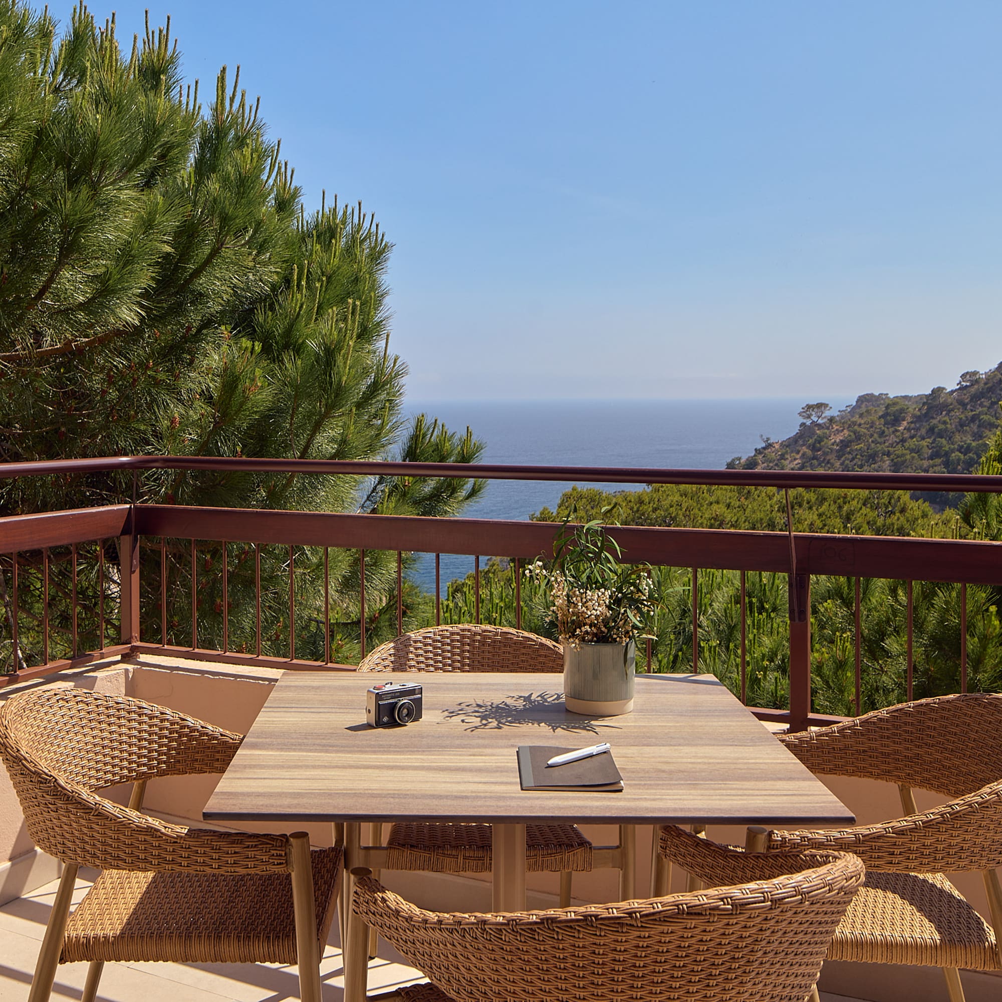 a table and chairs on a balcony overlooking a body of water