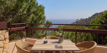 a table and chairs on a balcony overlooking a body of water