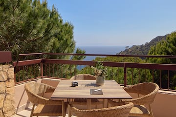 a table and chairs on a balcony overlooking a body of water