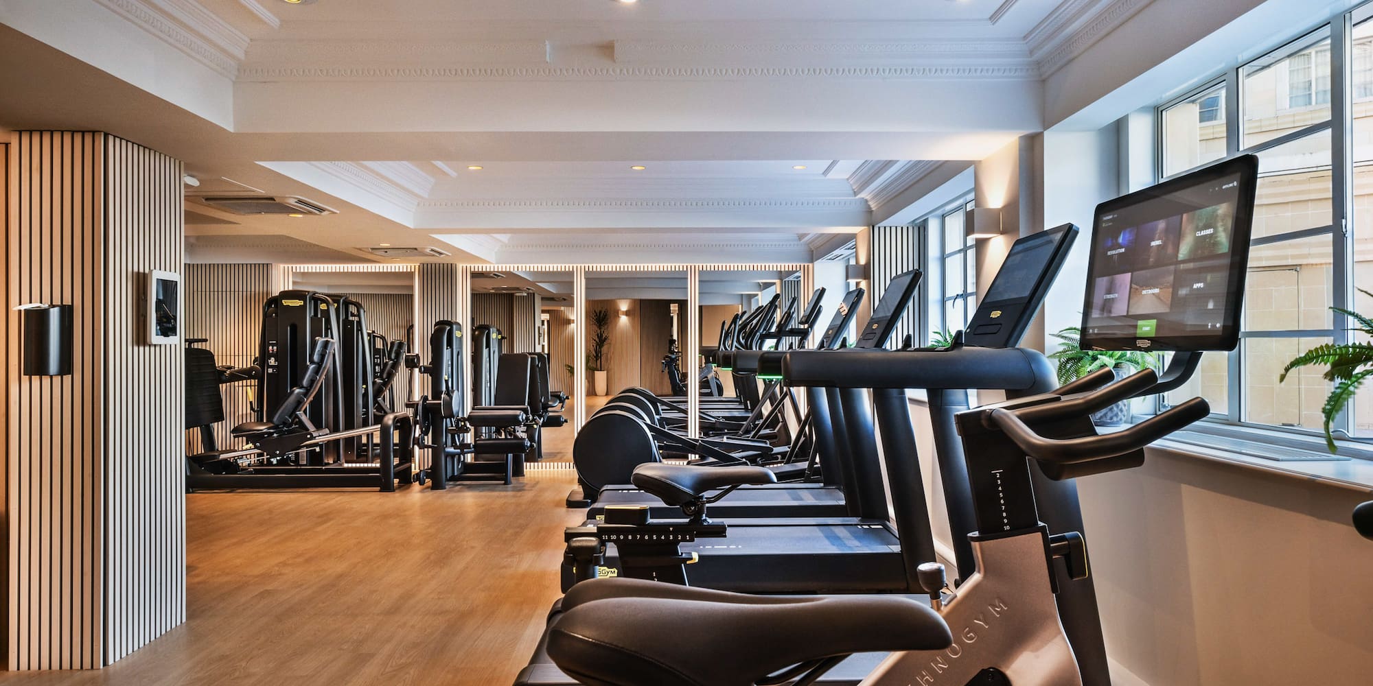 a room with exercise machines and a large window