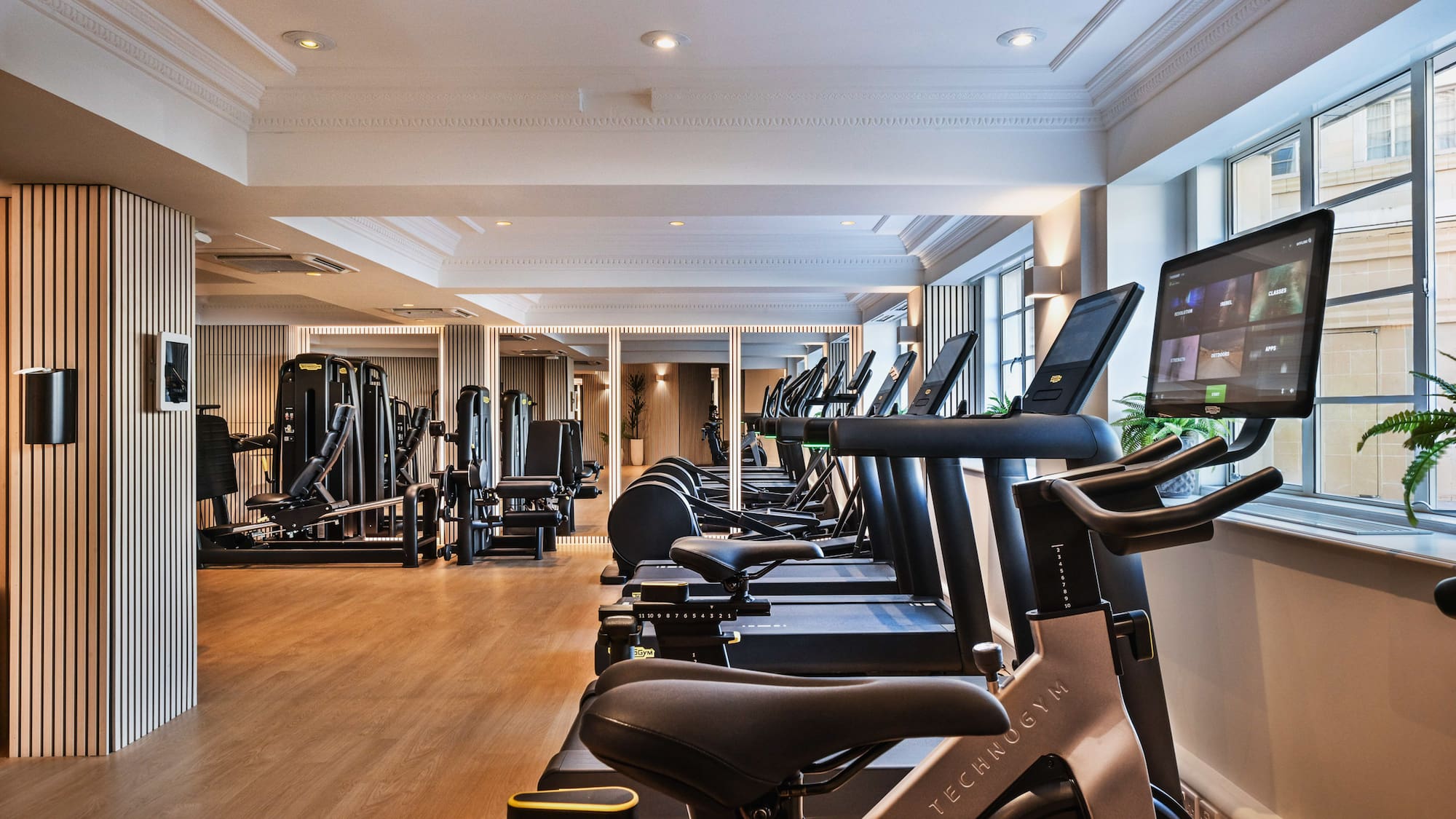 a room with exercise machines and a large window