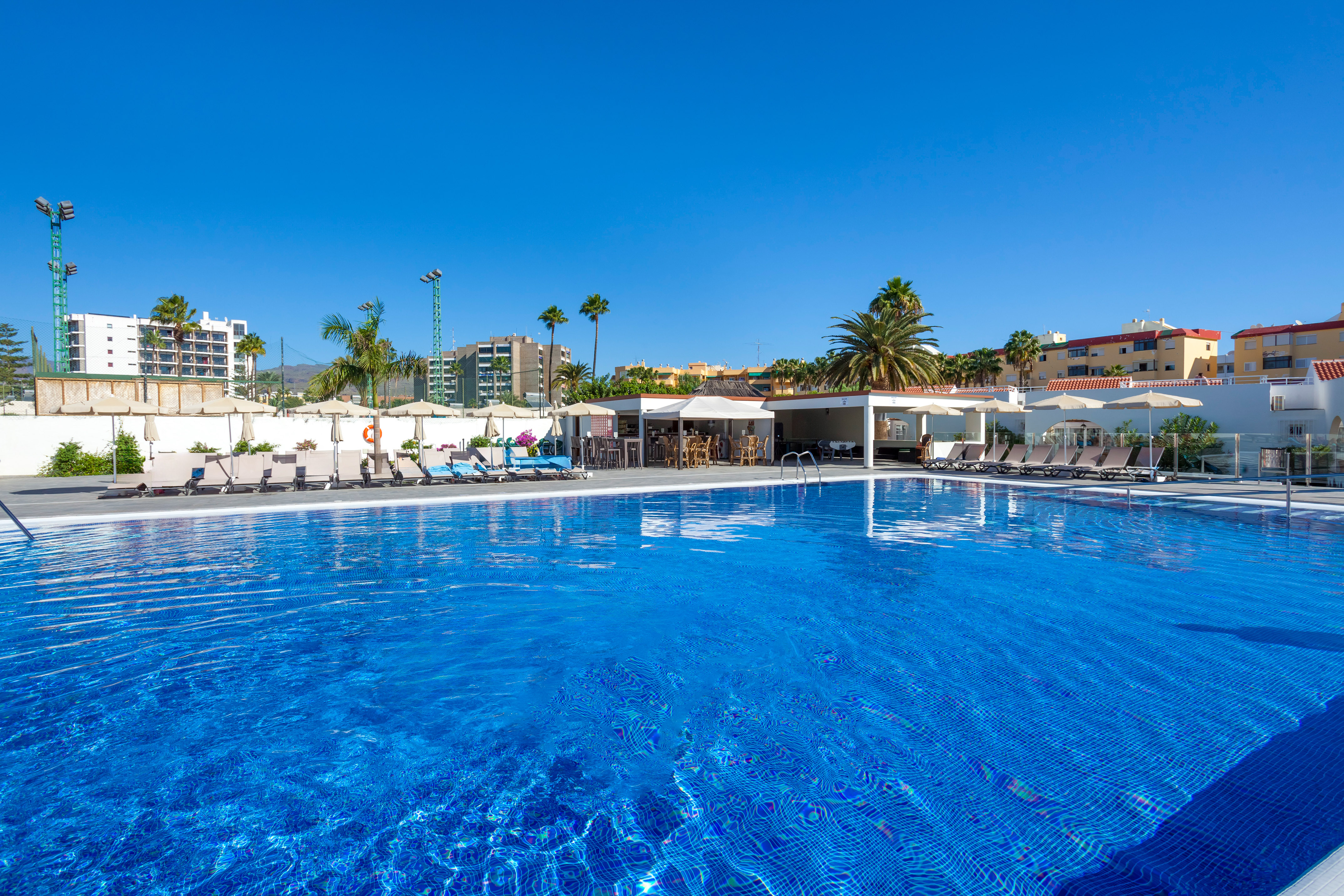 a pool with chairs and umbrellas