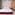 Modern bedroom with red velvet bed, patterned wallpaper, wood wardrobe, marble.