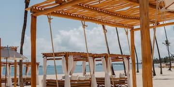 a beach with a canopy and a bed