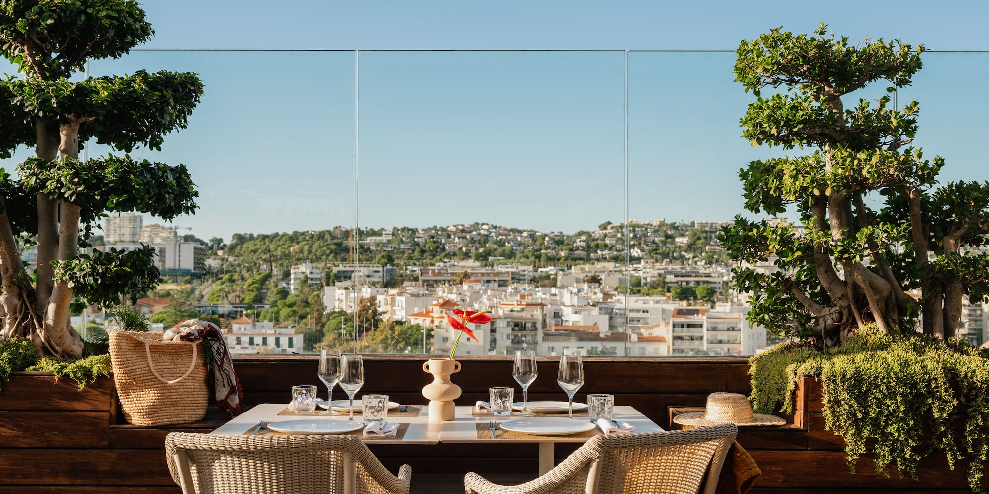 a table with wine glasses and a view of a city