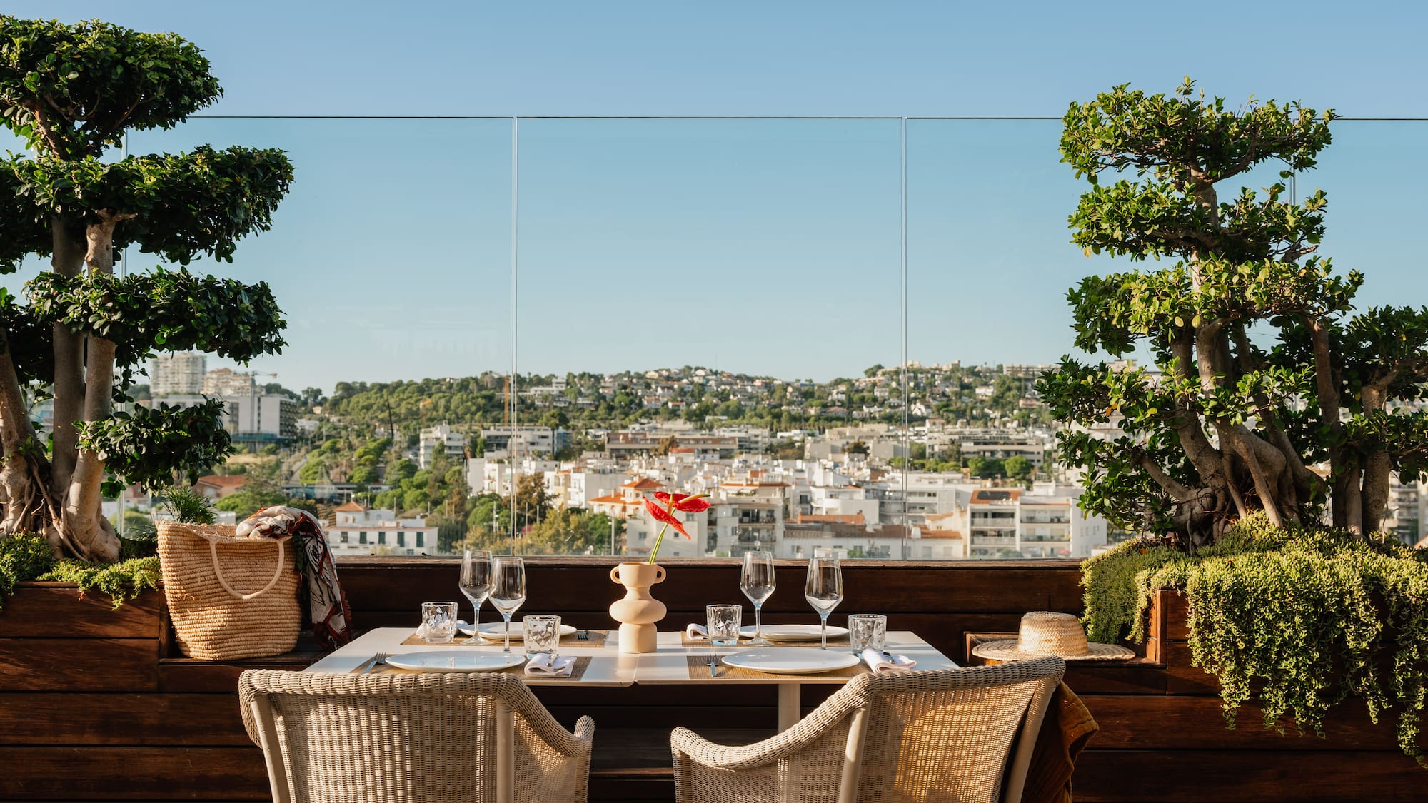 a table with wine glasses and a view of a city