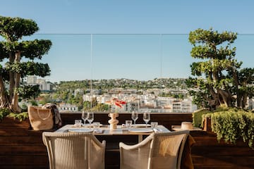 a table with wine glasses and a view of a city